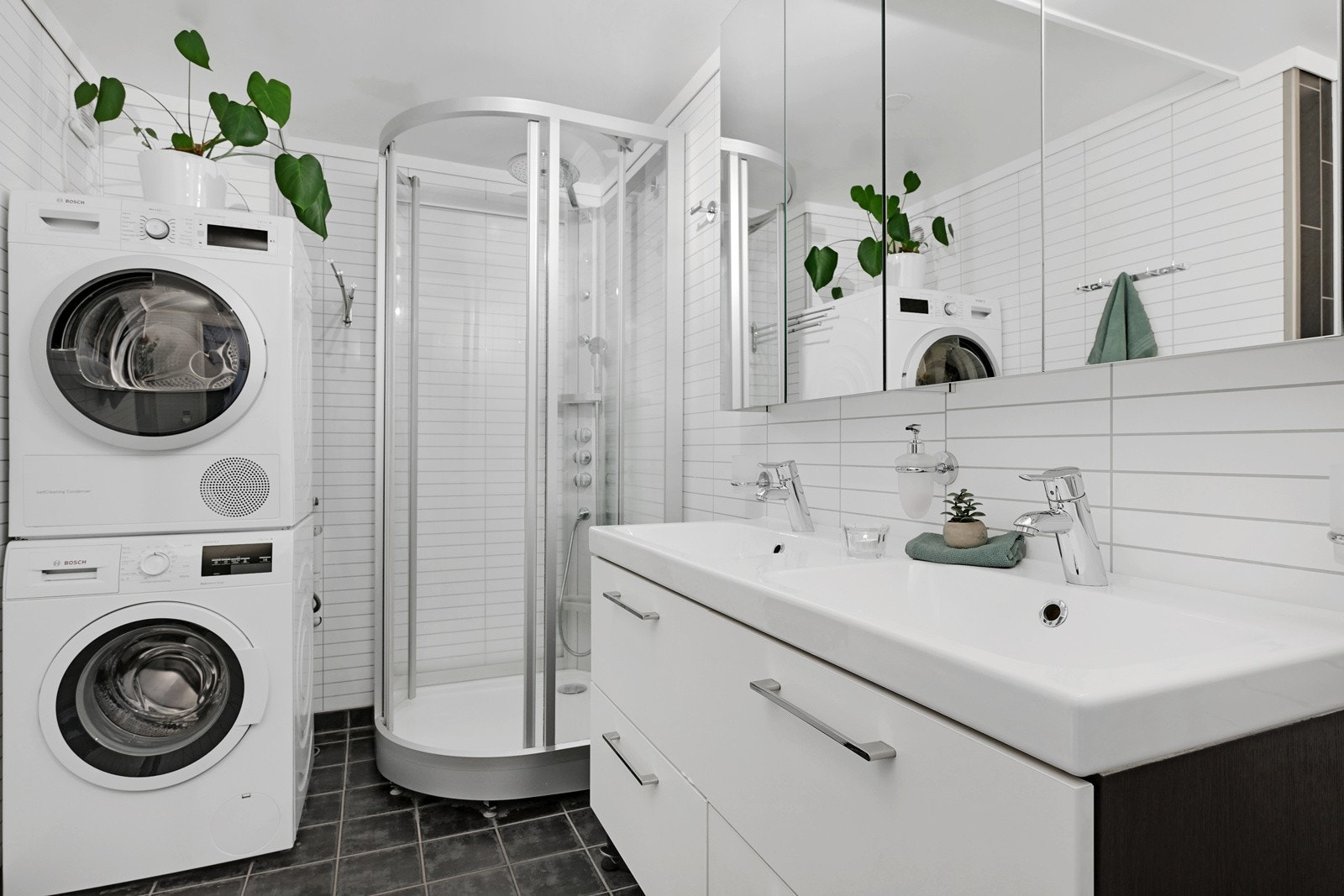 Badet har gulvvarme, dobbelservant, dusjkabinett, veggmontert toalett og opplegg for vaskemaskin. Galleribilde