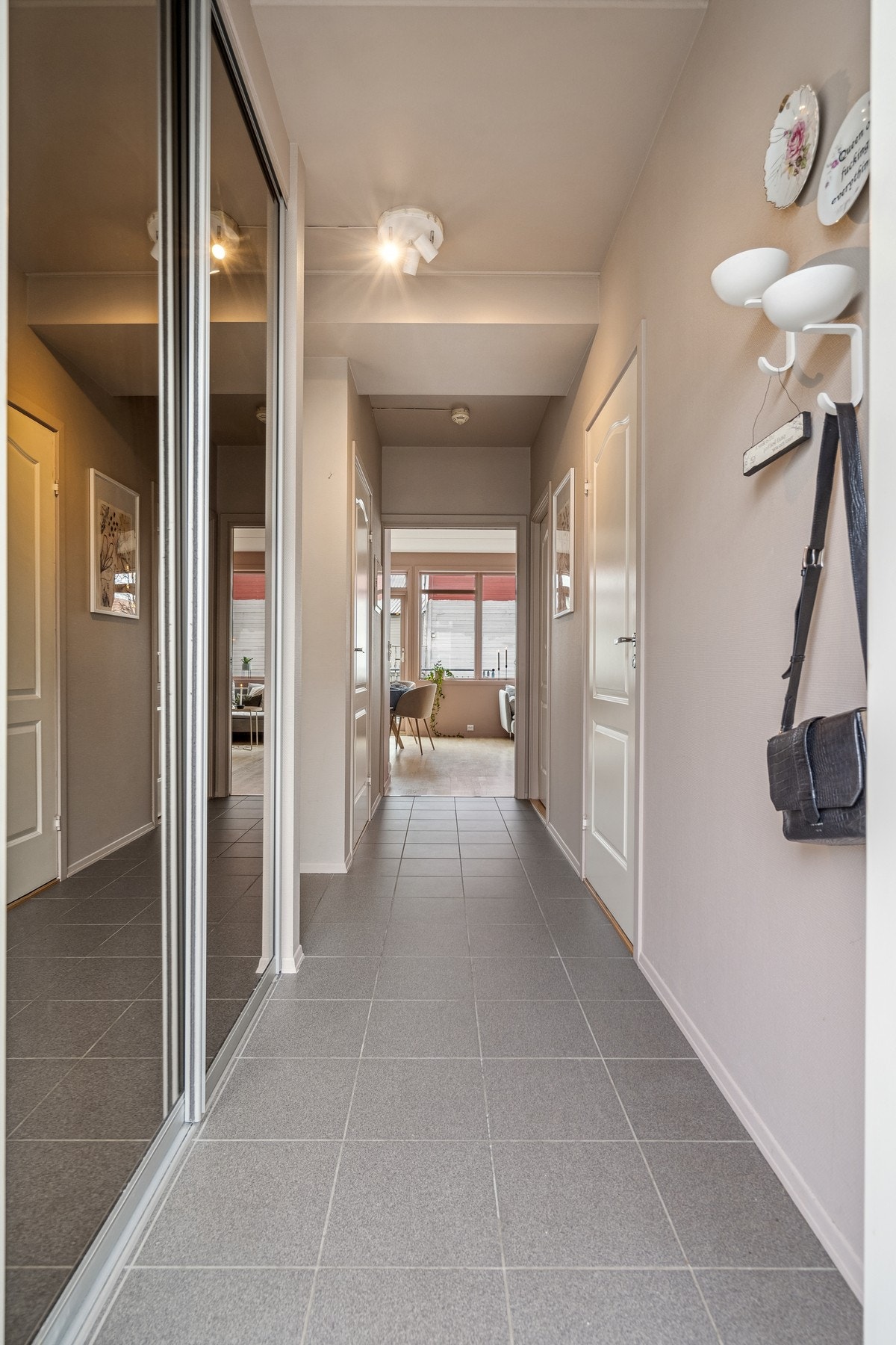 Velkommen inn. Innbydende entre med flislagt gulv og en praktisk skyvedørsgarderobe med speildører. Galleribilde