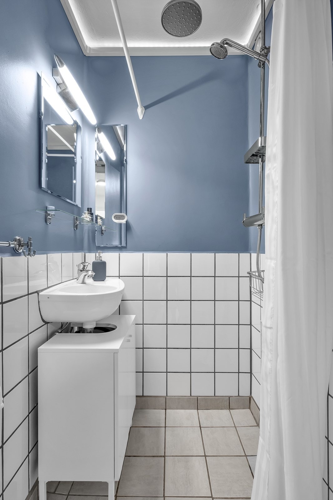 Badet har fliser på gulv og delvis flislagte vegger, ellers malte mur/betong. Galleribilde