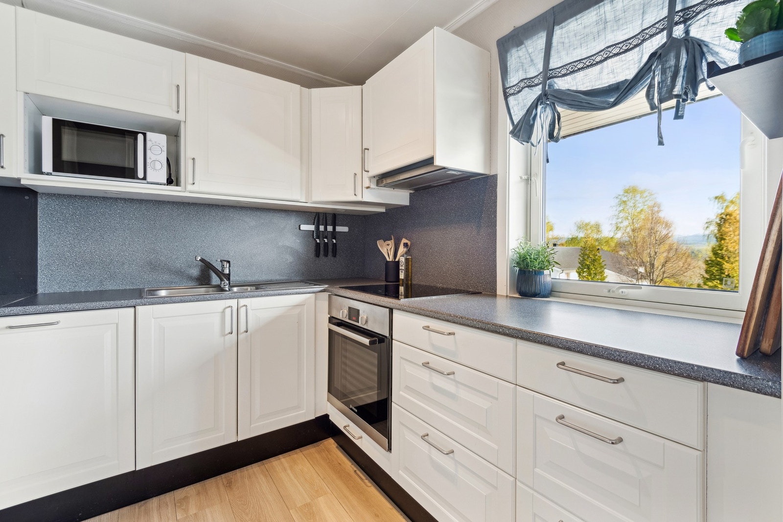 Lyst og romslig kjøkken med mye skap- og benkeplass. Ny varmtvannsbereder, platetopp og gulv på kjøkken i 2022. Galleribilde