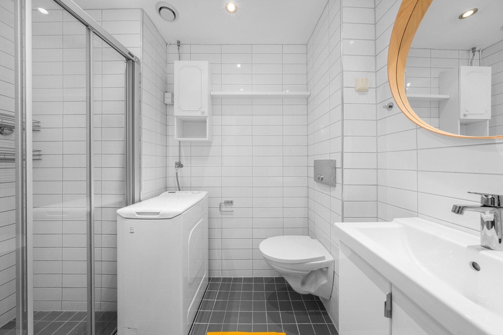 Badet er utsmykket med lyse fliser på vegg og gulv, varmekabler i gulv, og glatt malt himling med downlights. Galleribilde