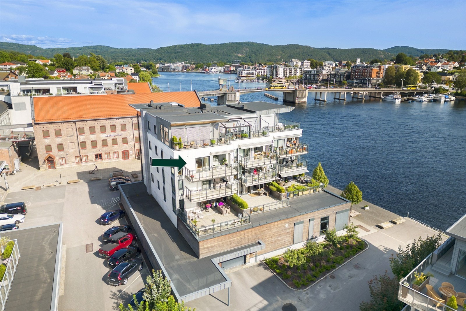 Leiligheten merket med pil. Det er egen biloppstillingsplass i felles parkeringsanlegg nederst i bygget. Utvendig gjesteparkering. Galleribilde