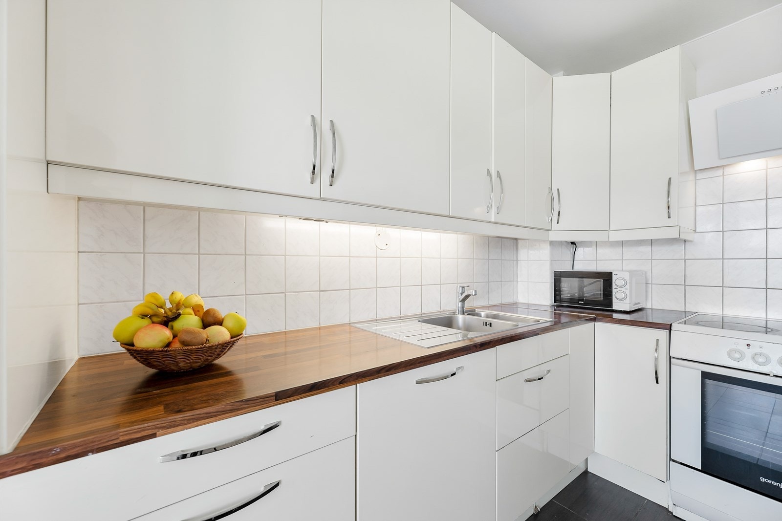 Innredningen har hvite slette fronter og laminerte benkeplater Galleribilde