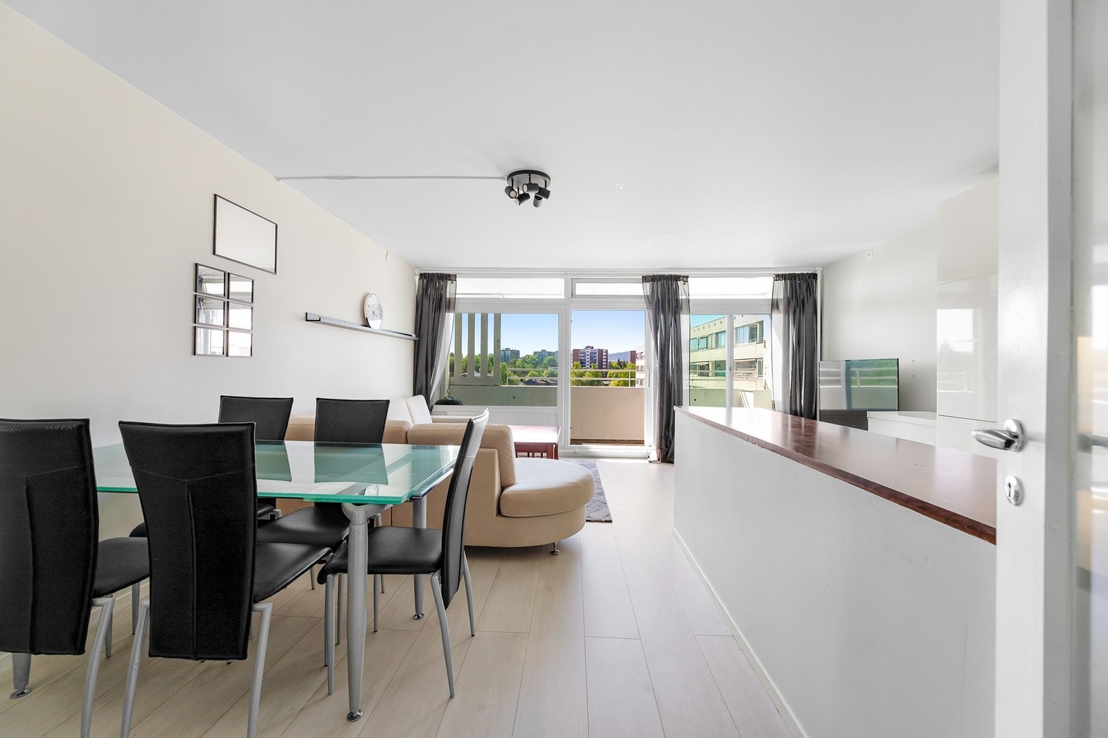 Den gjennomgående løsningen og de store vinduene gir stuen en lys og luftig atmosfære Galleribilde