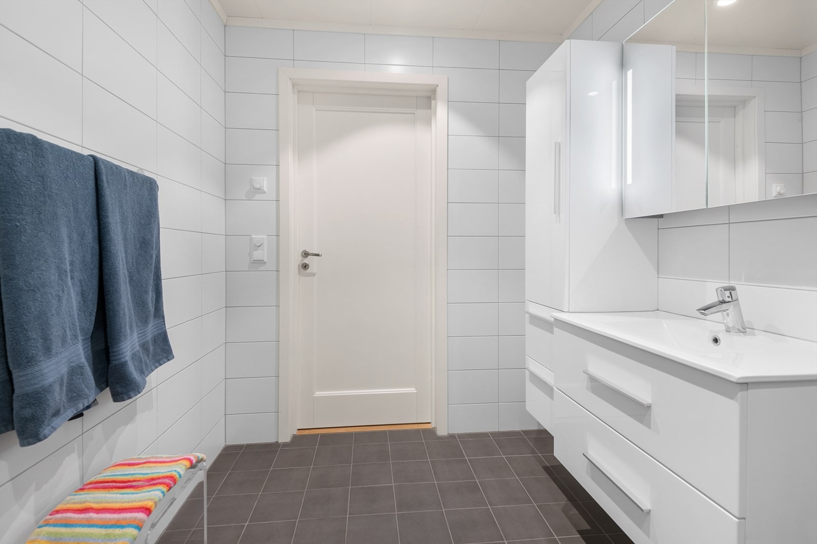 Videre er badet innredet med vegghengt toalett, og dusj med innfellbare vegger og regnfall Galleribilde