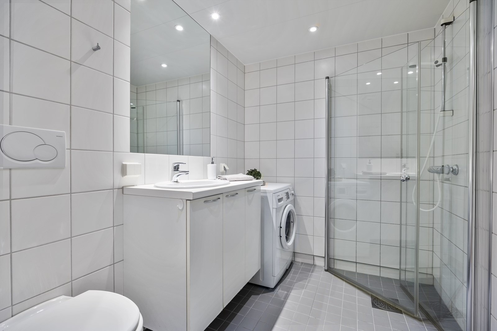 Pent flislagt bad fra byggeår med varmekabler i gulvet og downlights i taket Galleribilde