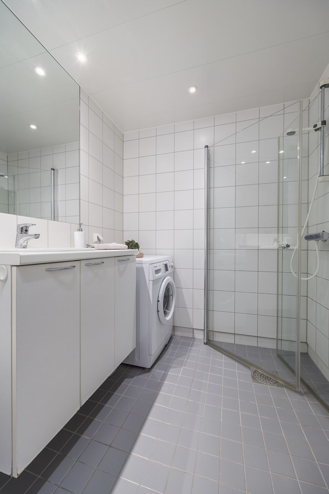 Baderomsinnredningen består av servantskap med god lagringsplass, dusjsone, vegghengt toalett og opplegg for vaskemaskin Galleribilde