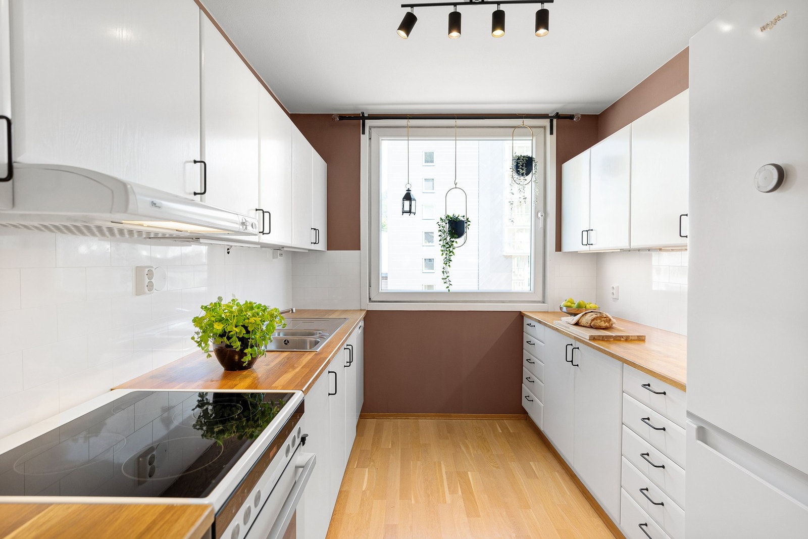 Pent kjøkken med malte, hvite fronter. Alle hvitevarer medfølger Galleribilde