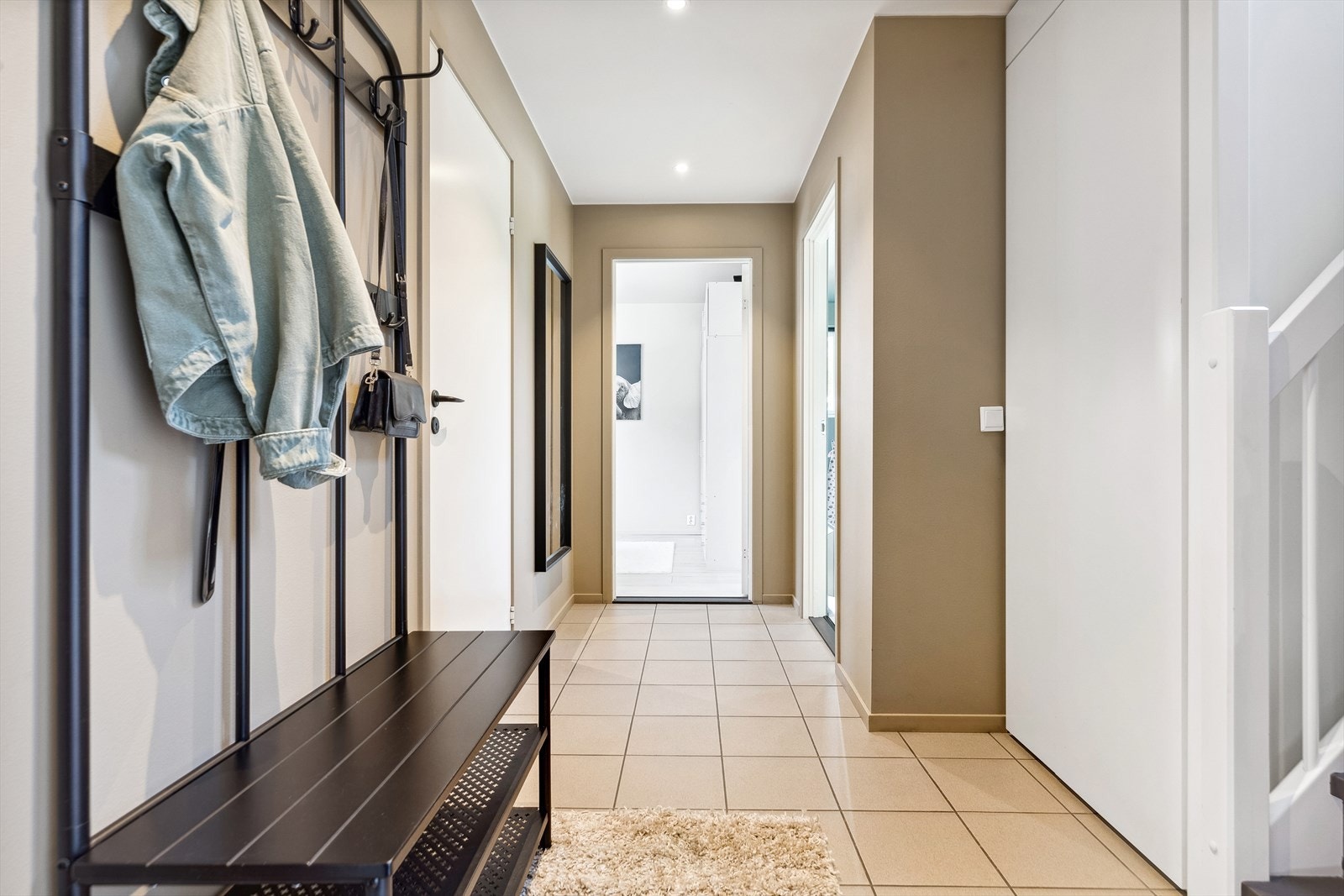 Boligen har en pen entré med ekstra oppbevaringsplass i et kott under trappen. Galleribilde