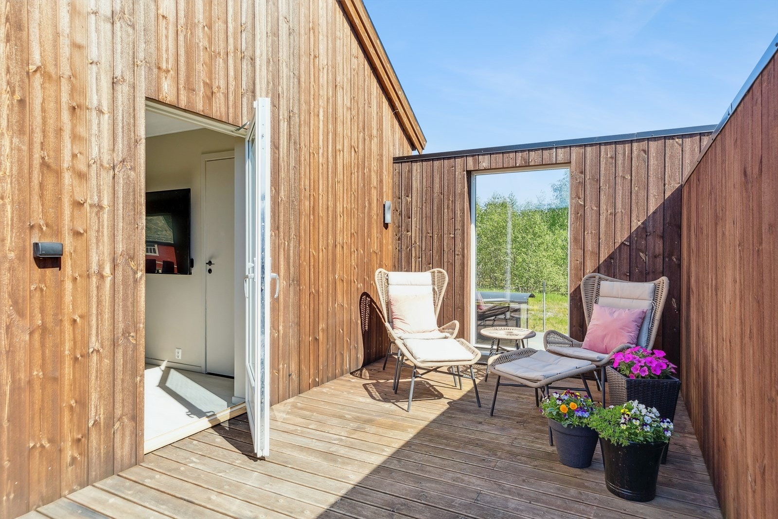 I en av veggene på terrassen er det satt inn et stort vindu som sikrer utsikten. Galleribilde