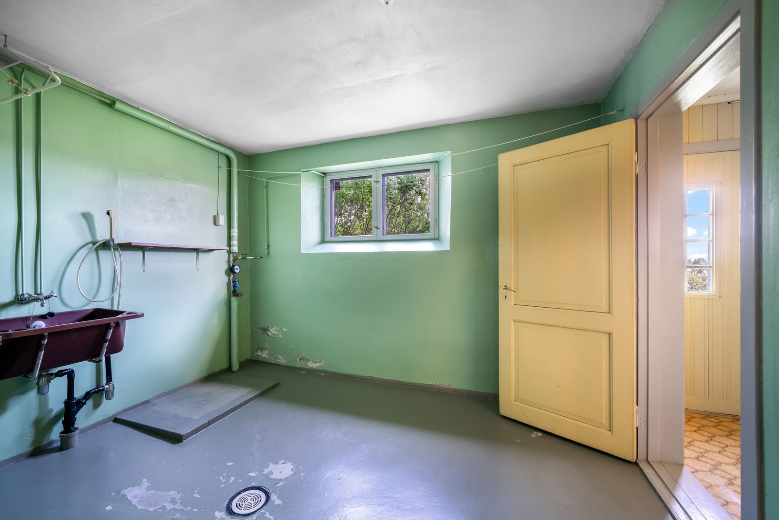 Stor vaskekjeller med egen inngang. Utstyrt med vegghengt utslagsvask i plast med to-greps blandebatteri. Opplegg for vaskemaskin. Galleribilde