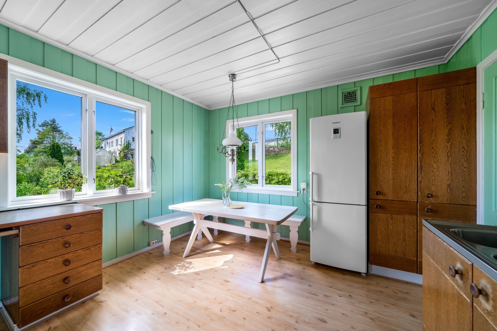 Selger opplyser om at kjøkken er fra 1979. Gulv med belegg, vegger og himling med malt panel. Det er lagt flis mellom benkeplate og overskap. Innredning med slette fronter, laminert benkeplate, vaskekum i metall med ett-greps blandebatteri. Nisje for oppv Galleribilde