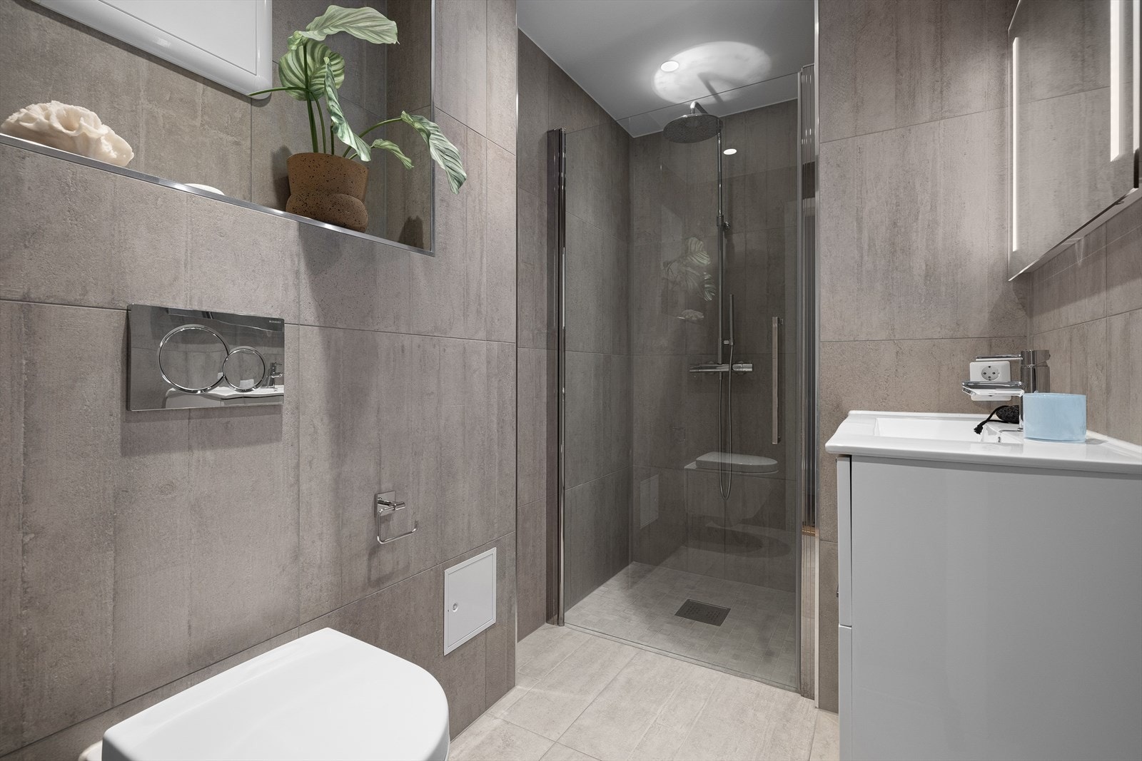 Nytt, rålekkert bad med stilige farge- og materialvalg. Det er flislagte overflater med 60x60cm fliser og 5x5cm i dusjsonen, behagelig gulvvarme og downlights i himling Galleribilde