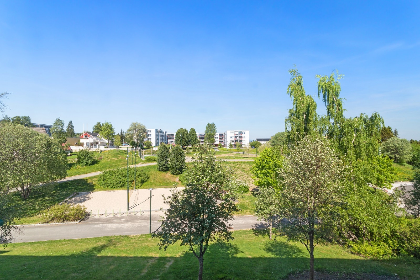 Dalen aktivitetspark rett utenfor leiligheten med volleyballbane, ballbinge og lekeplasser. Galleribilde