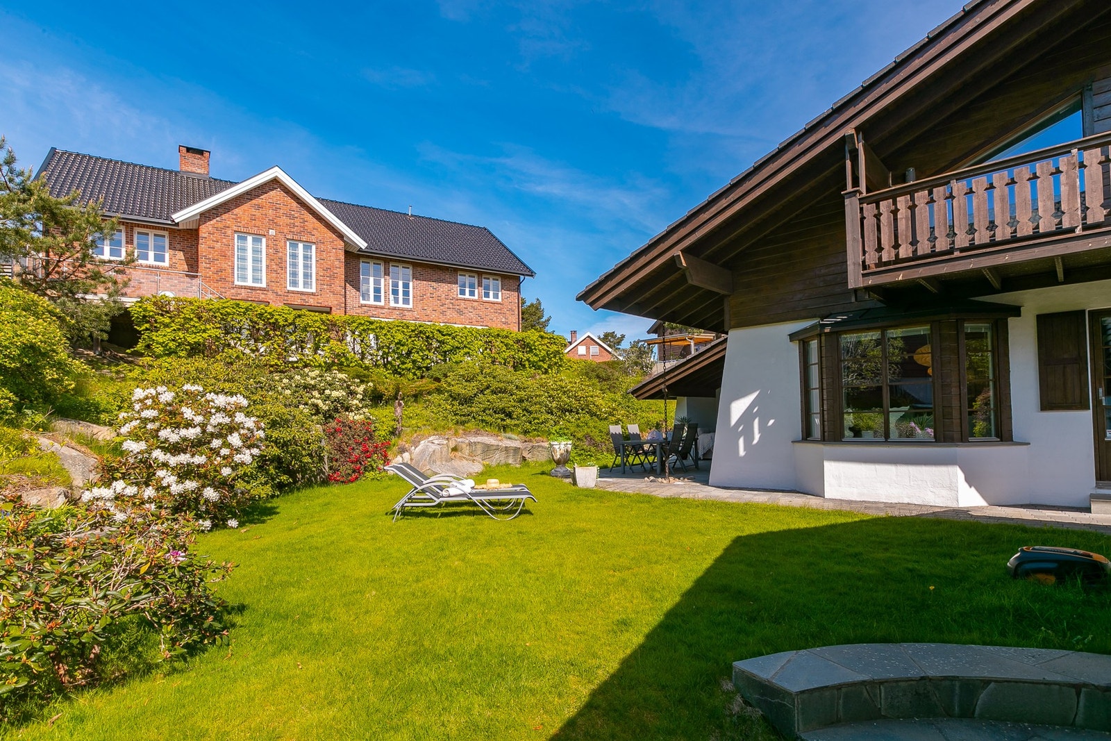 Gressplen og flotte busker som skaper en fin ramme i en skjermet & solrik hage Galleribilde
