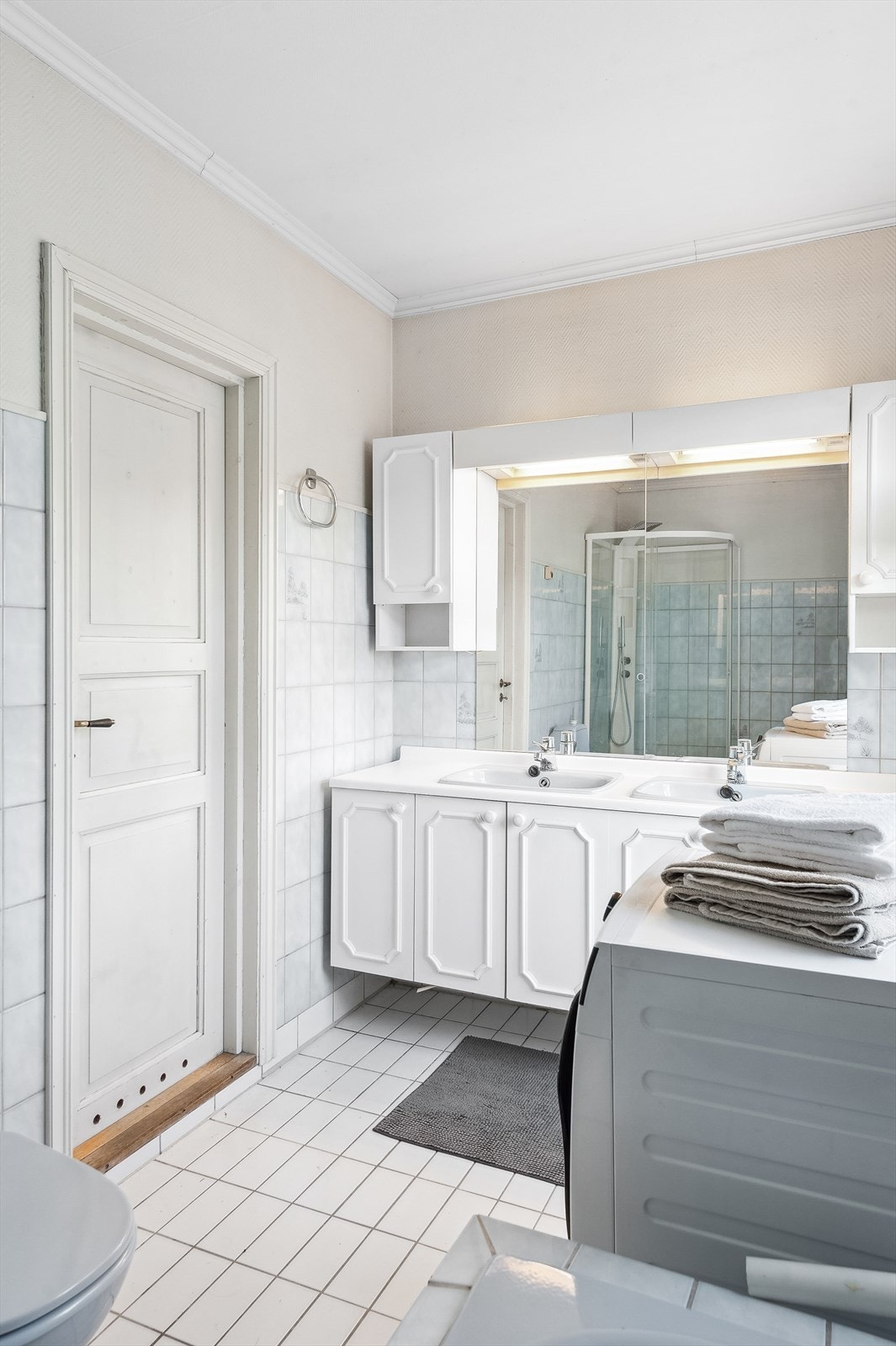 Innredningen består av speil, dobbel servant med underskap, dusjkabinett, innmurt badekar, gulvmontert toalett og opplegg for vaskemaskin. Galleribilde