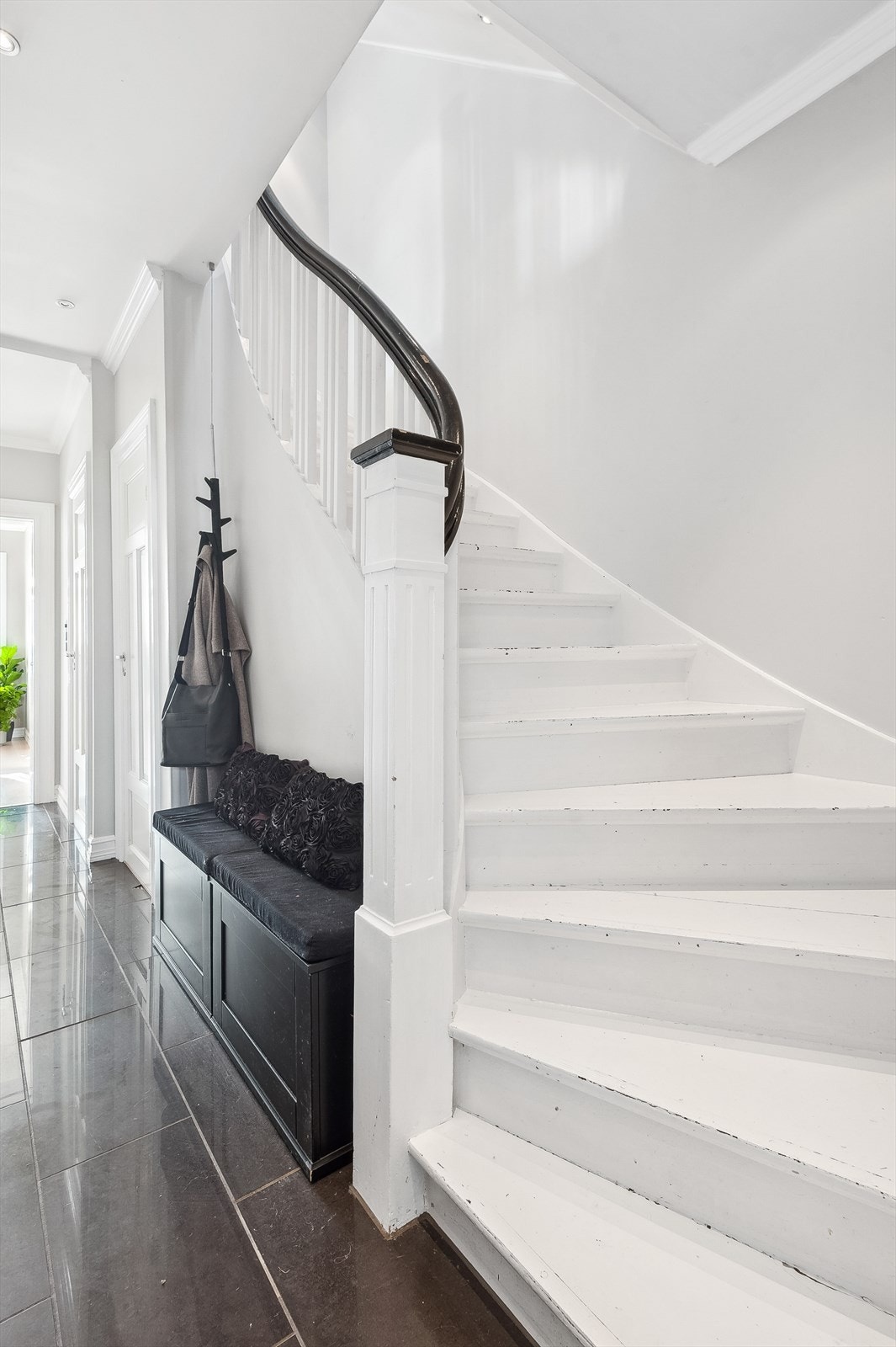 Lys og innbydende gang med fliselagt gulv og spotter i taket. Galleribilde