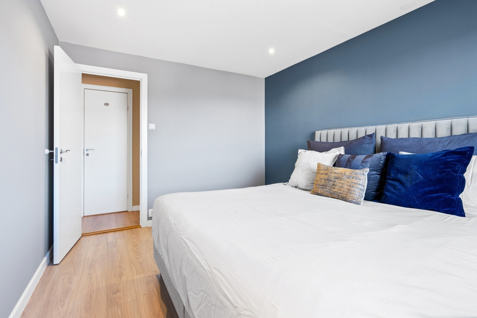 Downlights i himling, glatte malte overflater i spennende toner og 1-stavs laminatgulv. Galleribilde