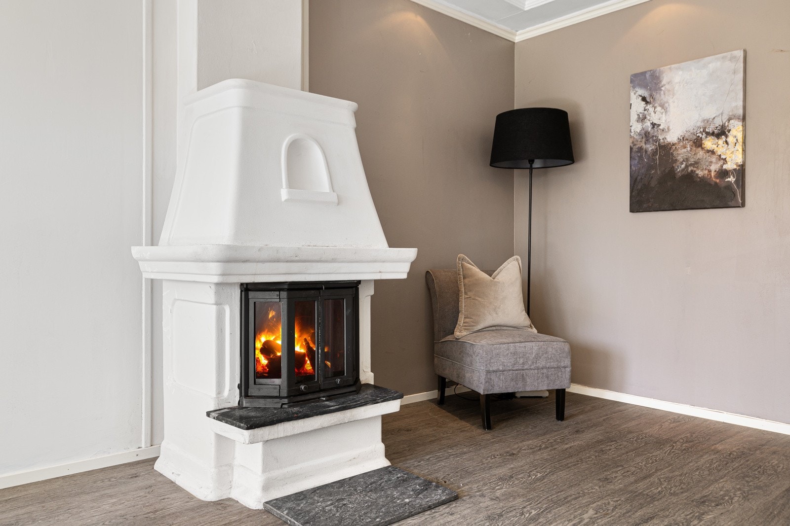 Stuen har en klassisk peis som gir ekstra varme og hygge. Galleribilde