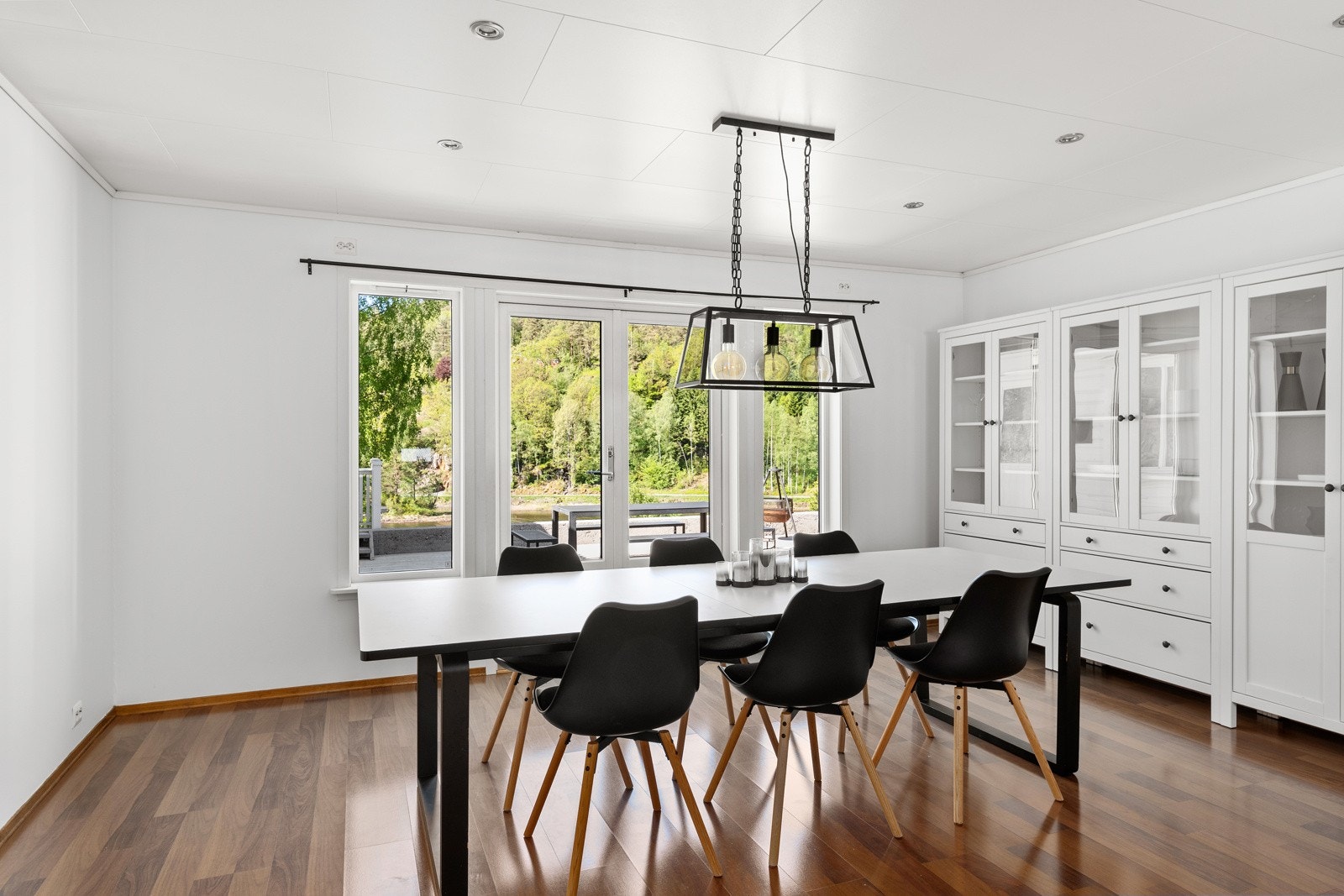 Spisestue med store vinduer som slipper inn rikelig med naturlig lys. Galleribilde