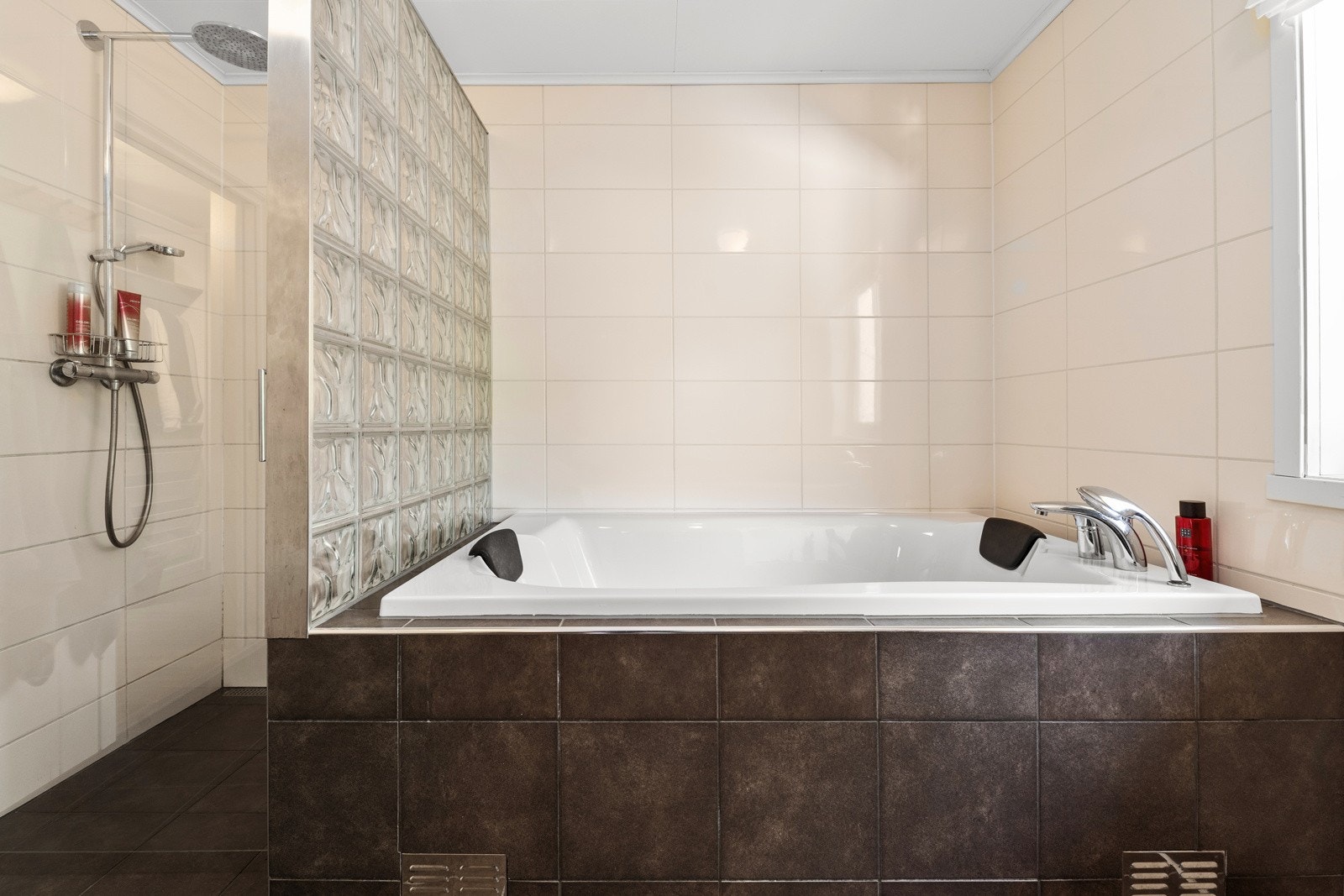 Dusjvegg i glass og dusj bak badekaret. Galleribilde