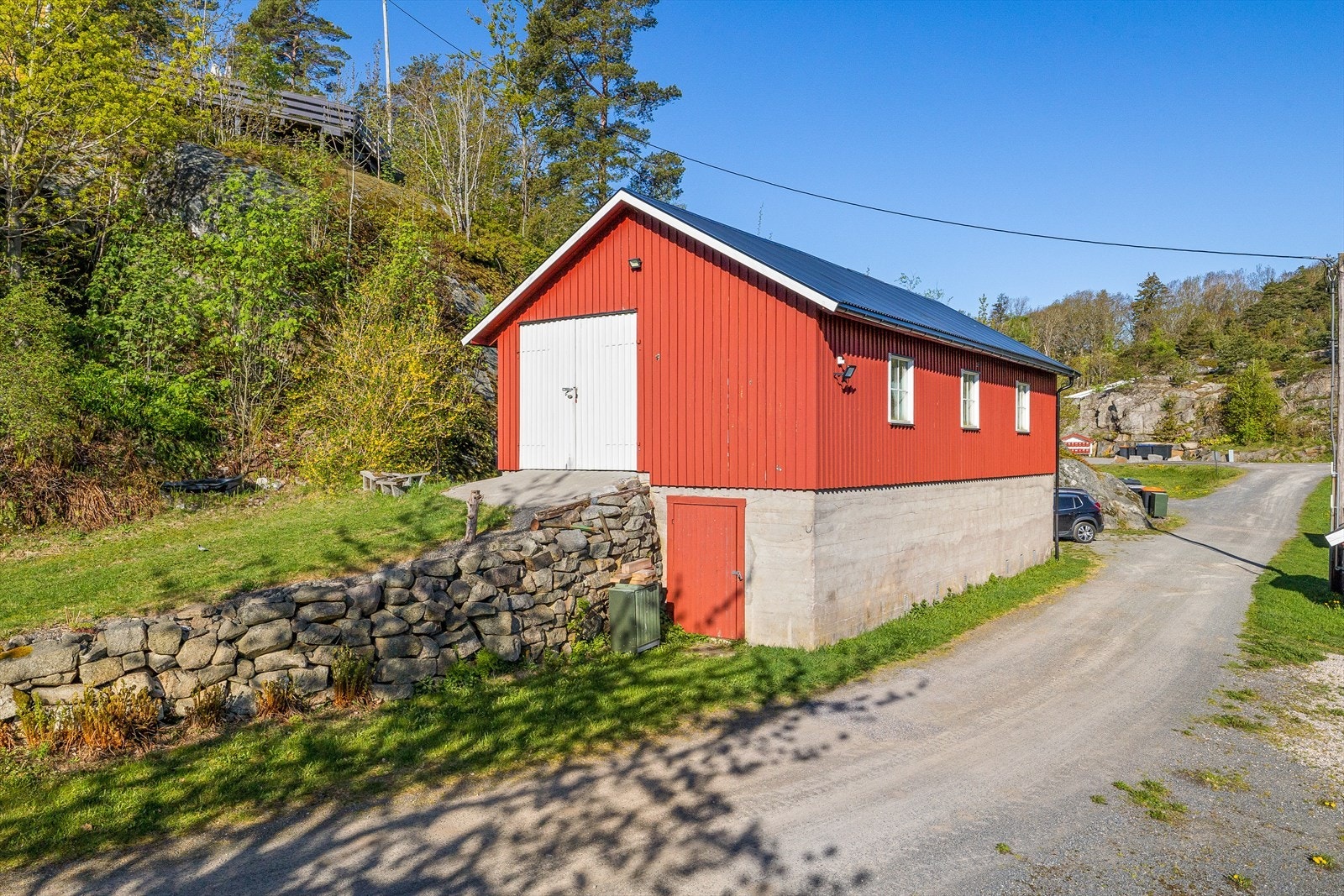 Låve med 2 lagerrom i underetasje og stort rom i 1. etasje. Låver er oppført i tre på mur og kledd med stående kledning. Saltak tekket med stålplater. Galleribilde