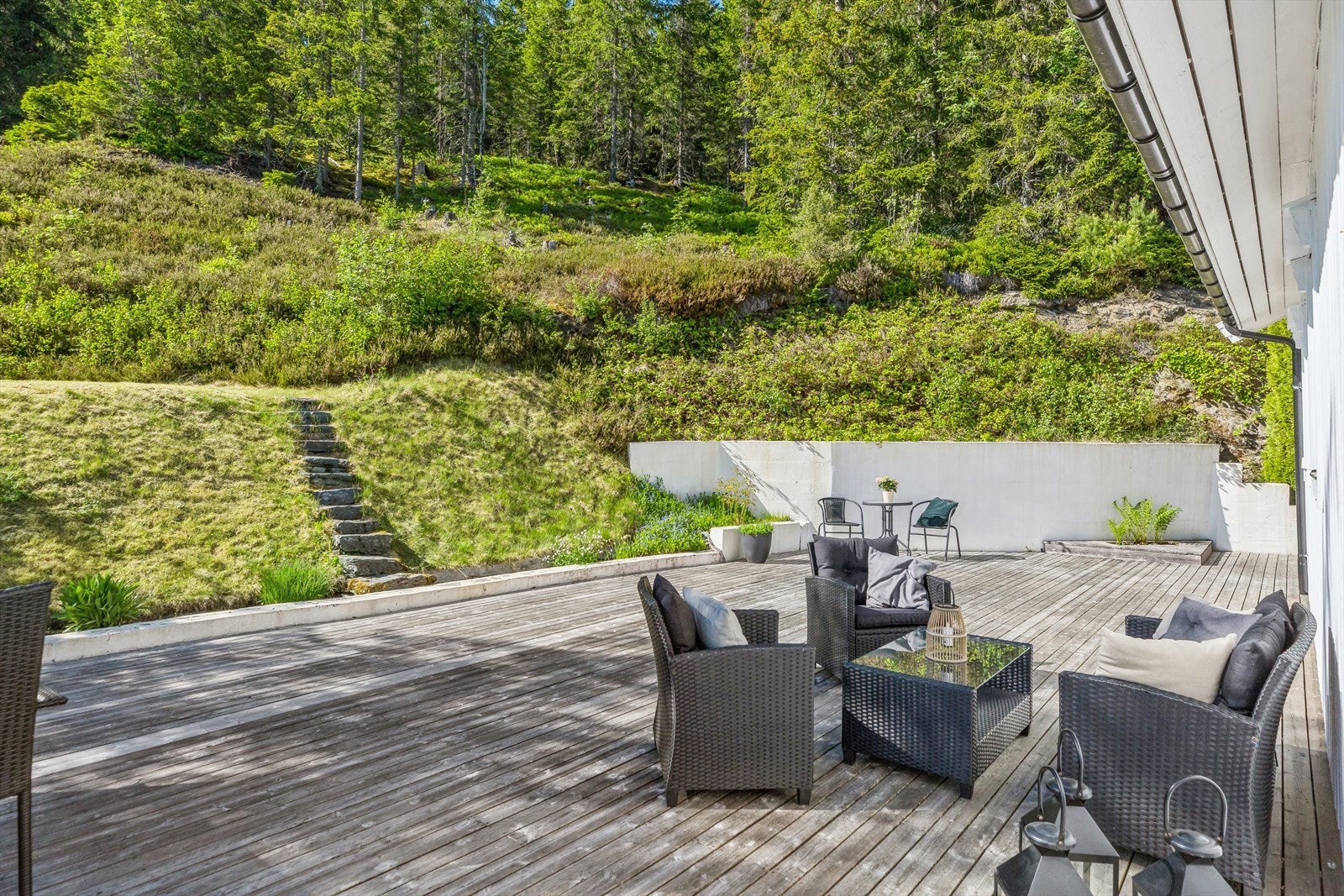 Fra verandaen er det trapp ned til en herlig terrasse på ca. 100 kvm, et usjenert uterom for hygge hele sommeren. Galleribilde