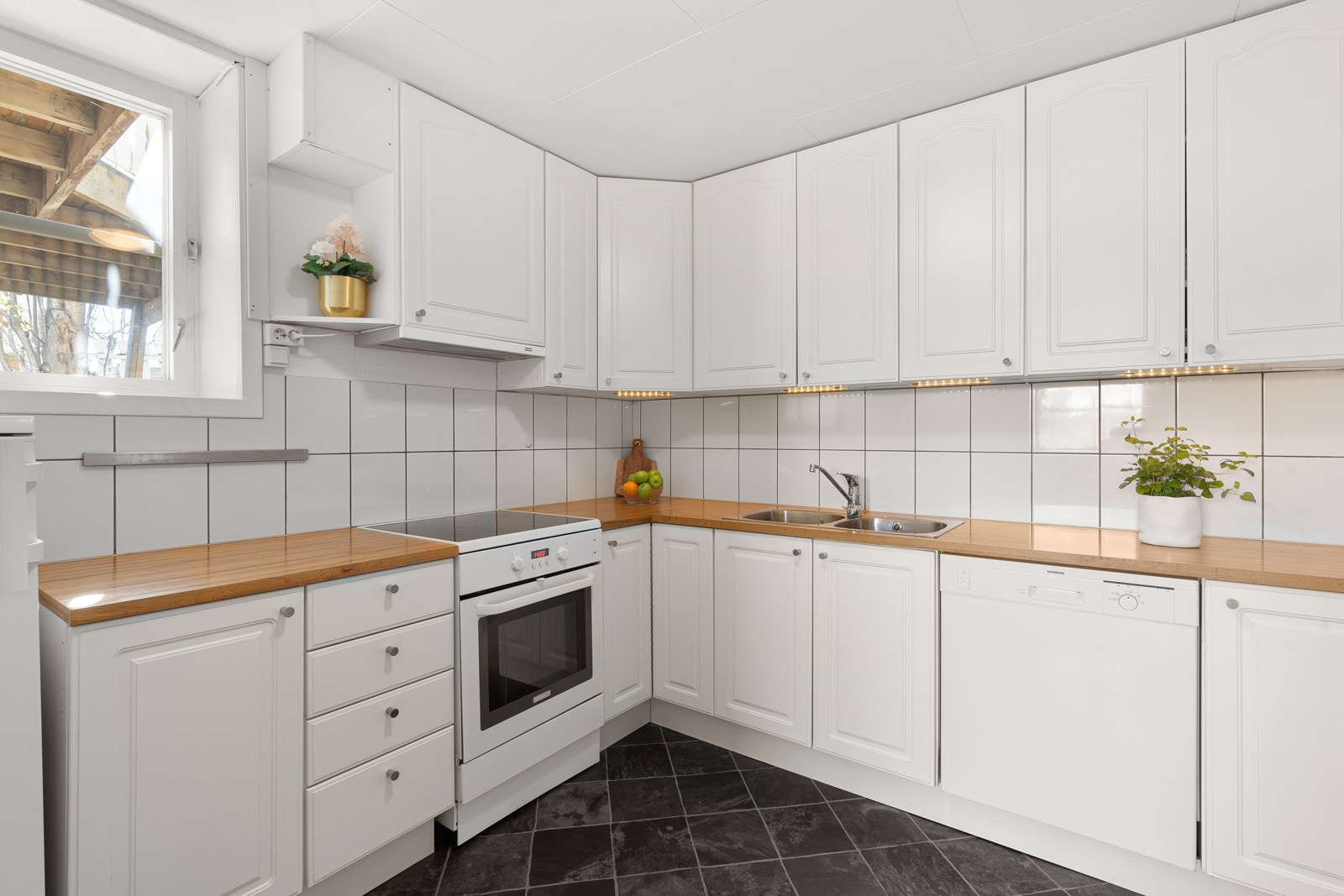 Det er belysning og fliser mellom over- og overskap Galleribilde