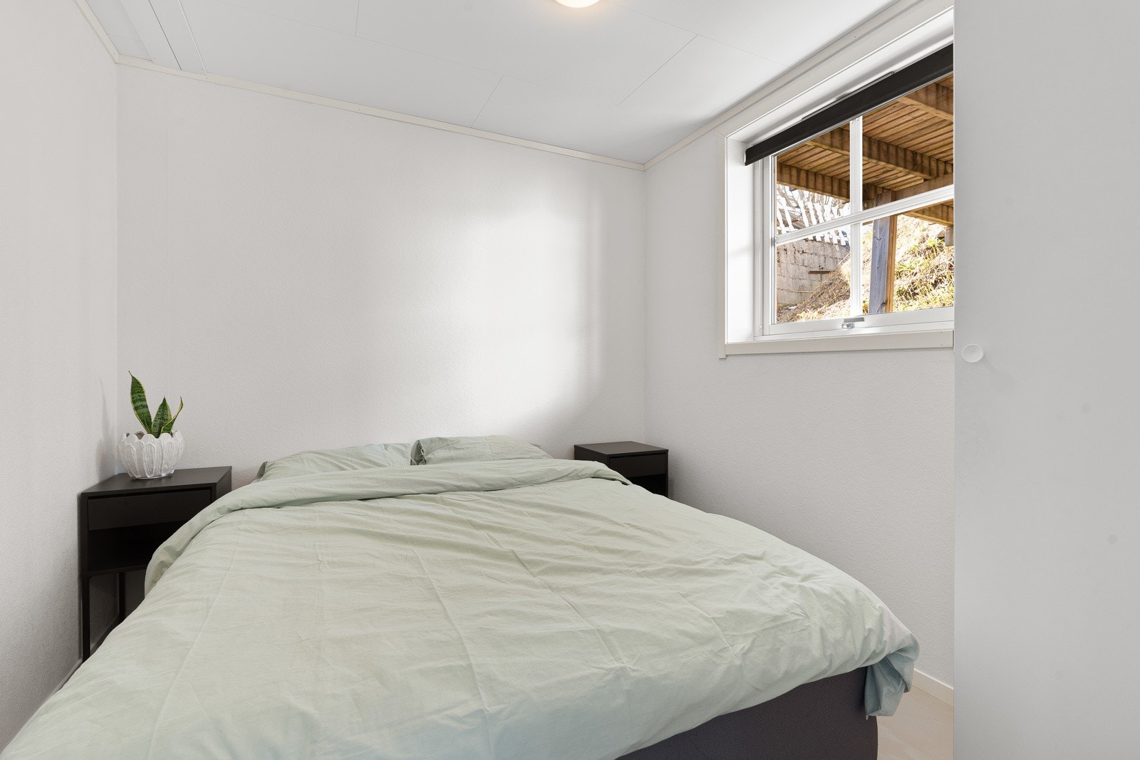 Soverom 2 med lyse veggoverflater, fliser på gulv og gulvvarme Galleribilde