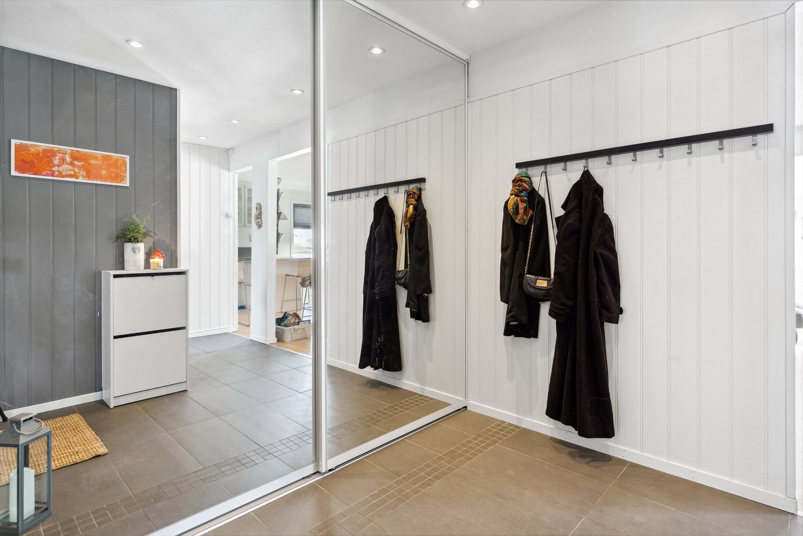 Entreen får godt med dagslys fra stuen/kjøkkenet og har godt med oppbevaringsplass i en romslig skyvedørsgarderobe. Galleribilde