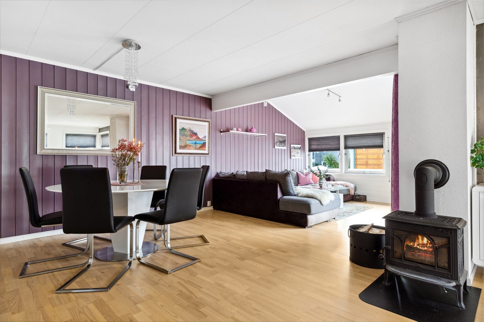 Taket i stuen er delvis skrånet, og som oppvarming er det både varmepumpe, vannbåren gulvvarme og peisovn. Galleribilde