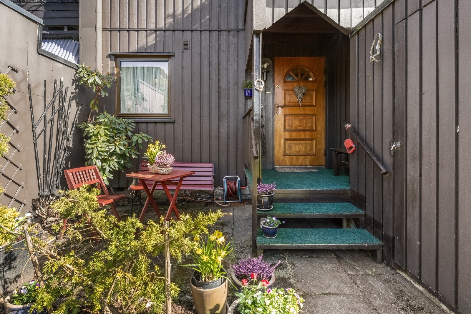 Rekkehuset har et overbygd inngangsparti, og en praktisk bod på 8 kvm er plassert til høyre i bildet. Galleribilde