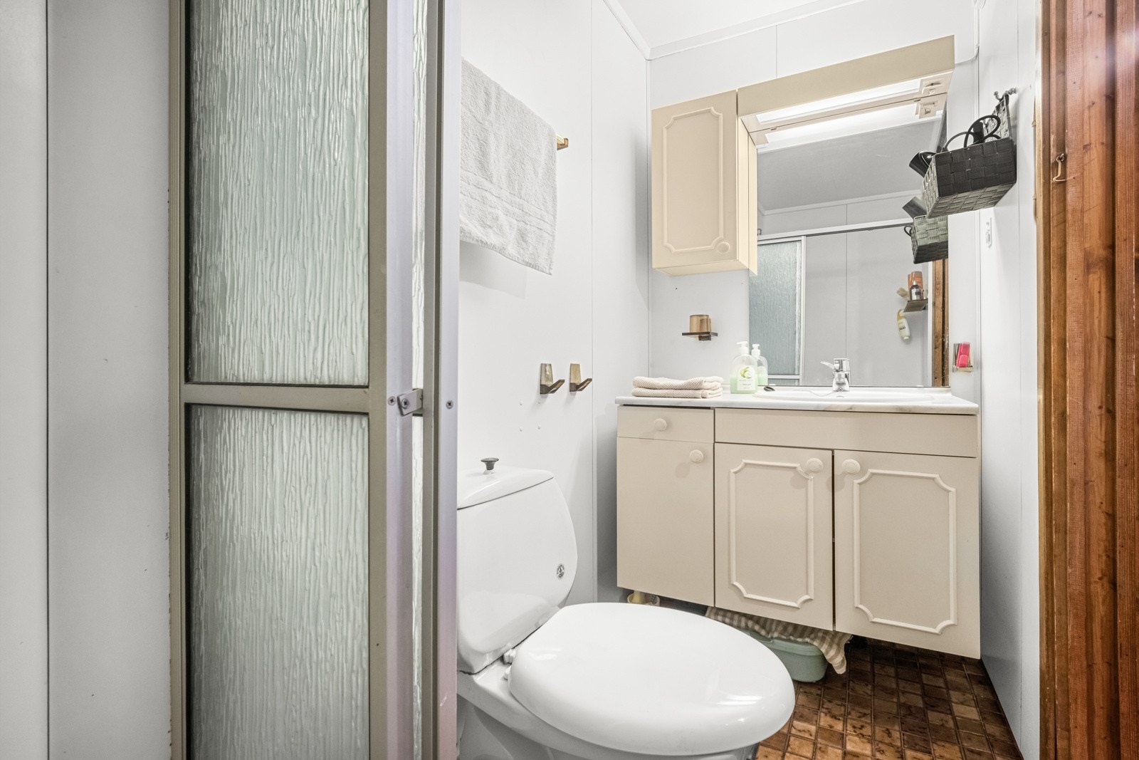 På badet er det toalett, varmekabler og et dusjhjørne med skyvedører. Baderomsinnredningen består av servant med lyse underskap, et veggskap og et speil med belysning. Galleribilde