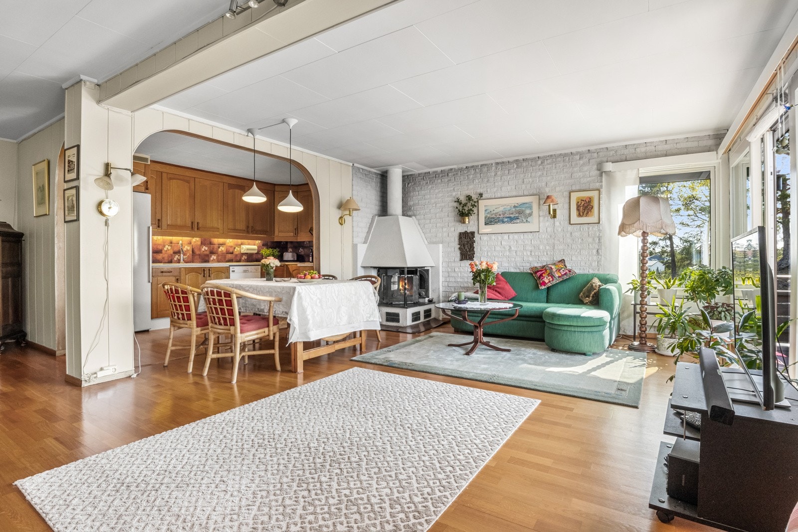 På stuegulvet er det lagt eikeparkett, mens veggene er kledd med trepanel, lysmalt panel og grå teglstein. Galleribilde