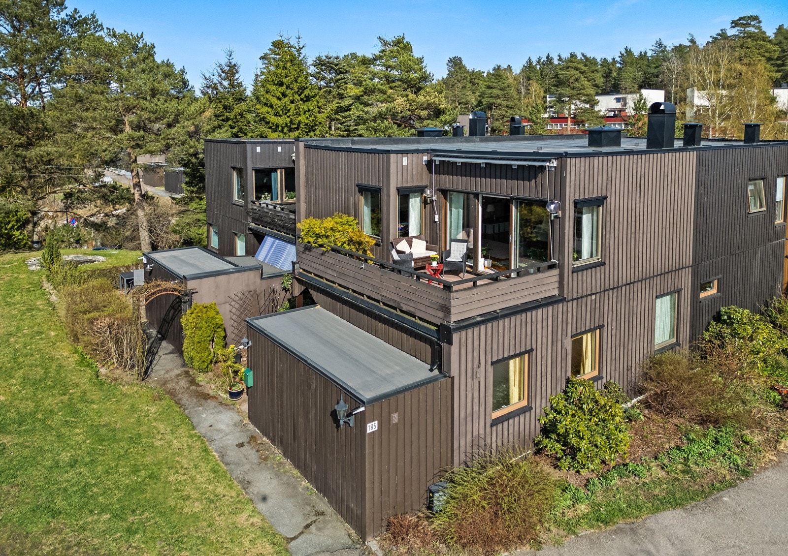 Ved inngangen har huset et steinlagt gårdsrom med levegg mot naboen og plass til benker eller kafésett. Galleribilde