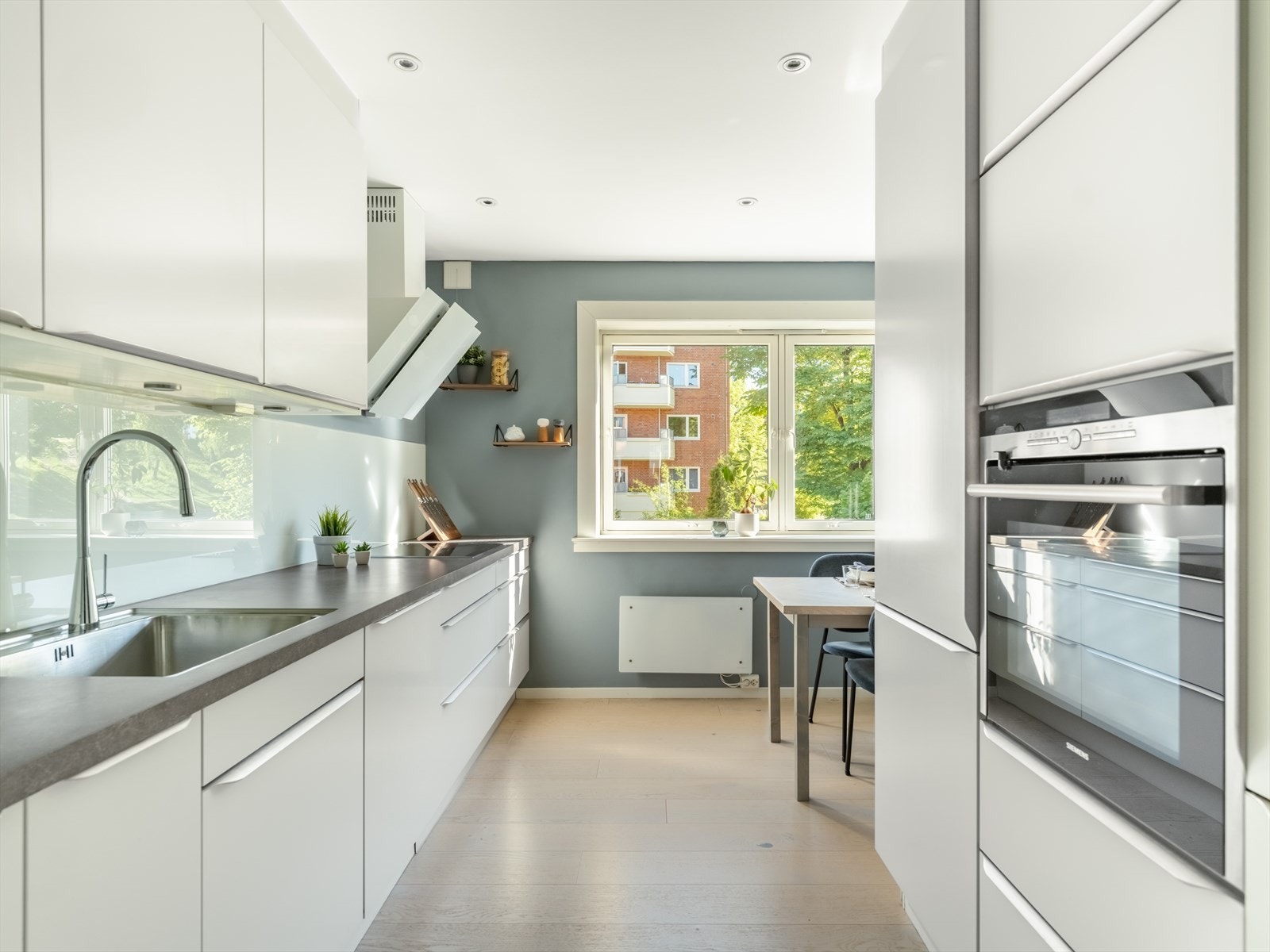 Stort og moderne kjøkken som fremstår med glatte fronter. Galleribilde