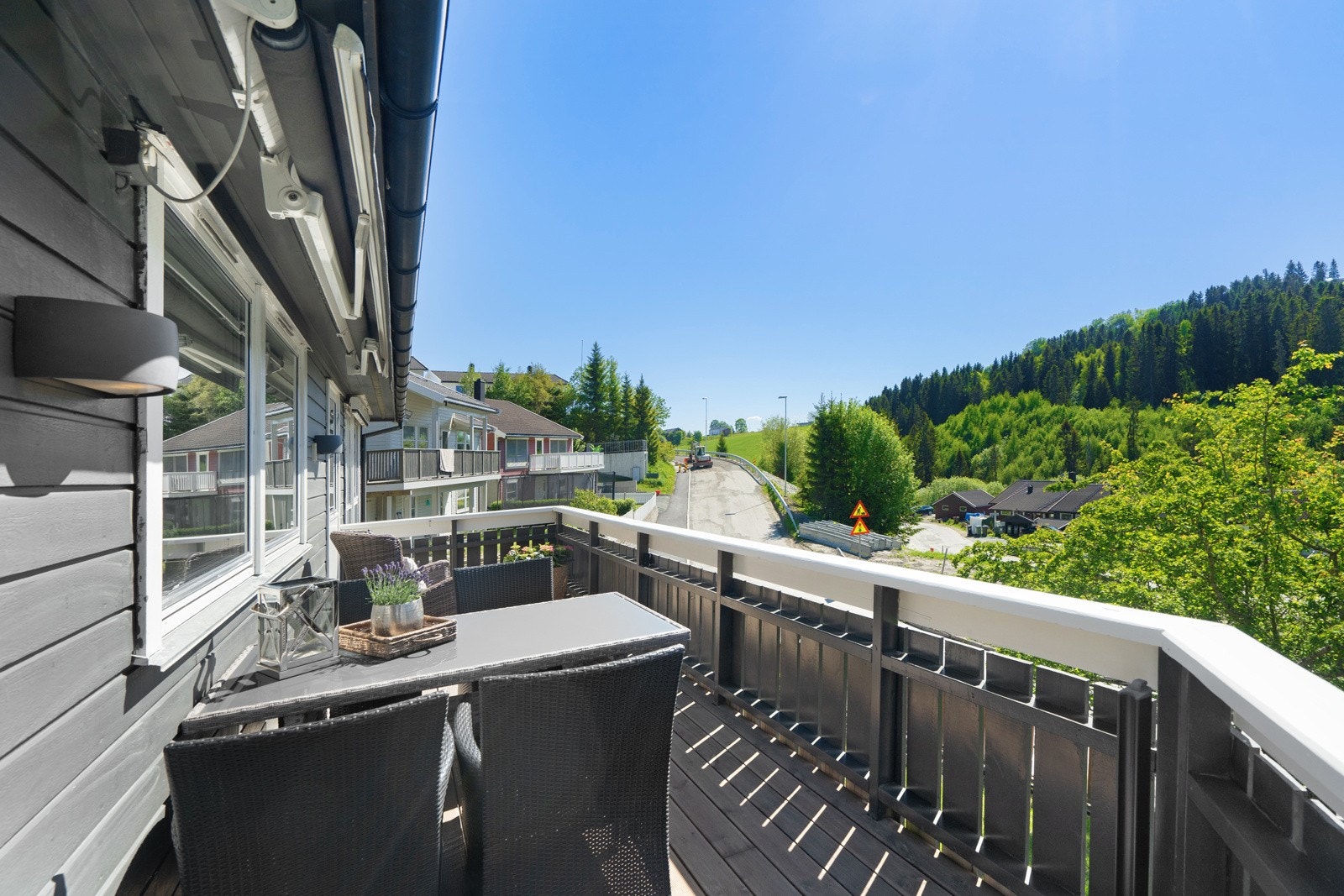 Fra balkongen har man utsikt over nærliggende bolig- og naturområder. Galleribilde