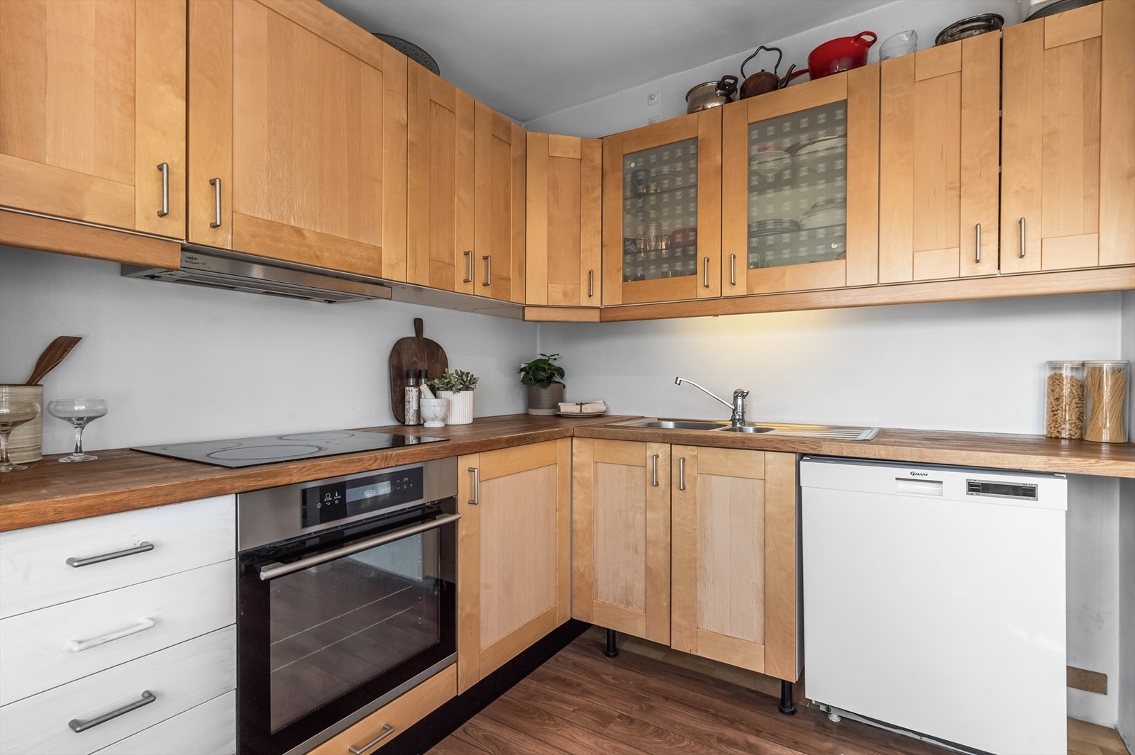 Kjøkkeninnredning med profilerte fronter. Eik benkeplate med nedfelt vaskekum og keramisk platetopp. Galleribilde