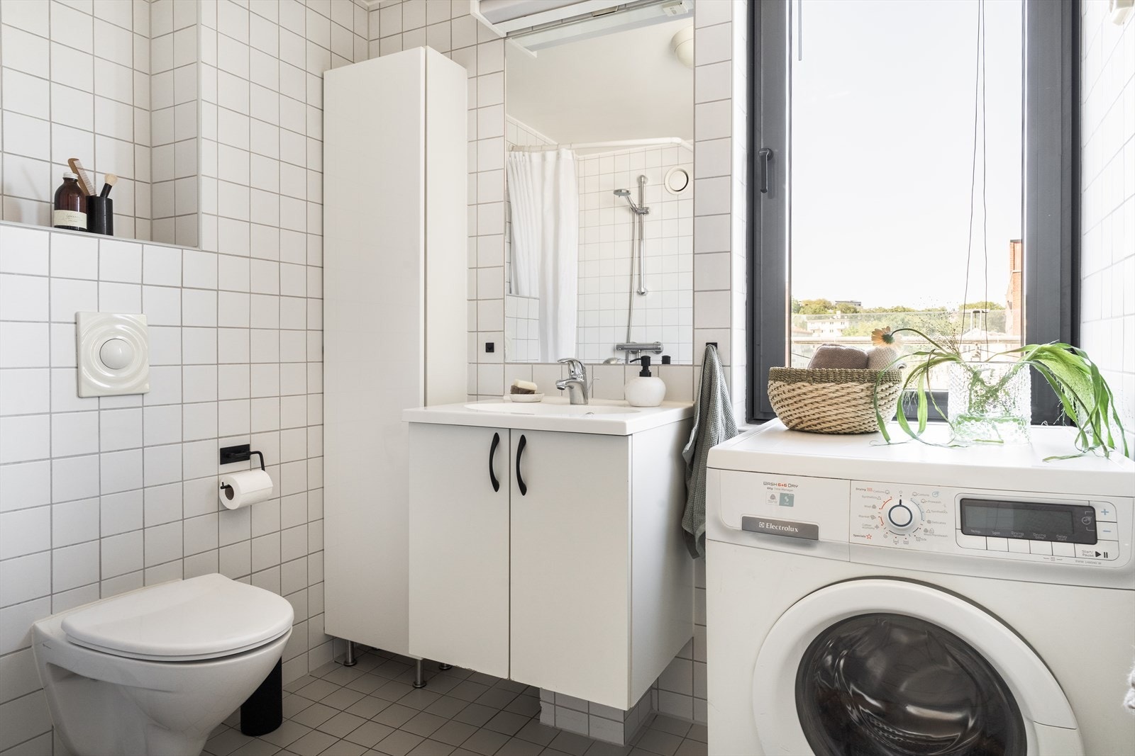 Pent, flislagt baderom med stilrent og tidløst materialvalg. Badet er også et lyst rom hvor et stor vindu gir godt lys i rommet og en god start på dagen. Galleribilde