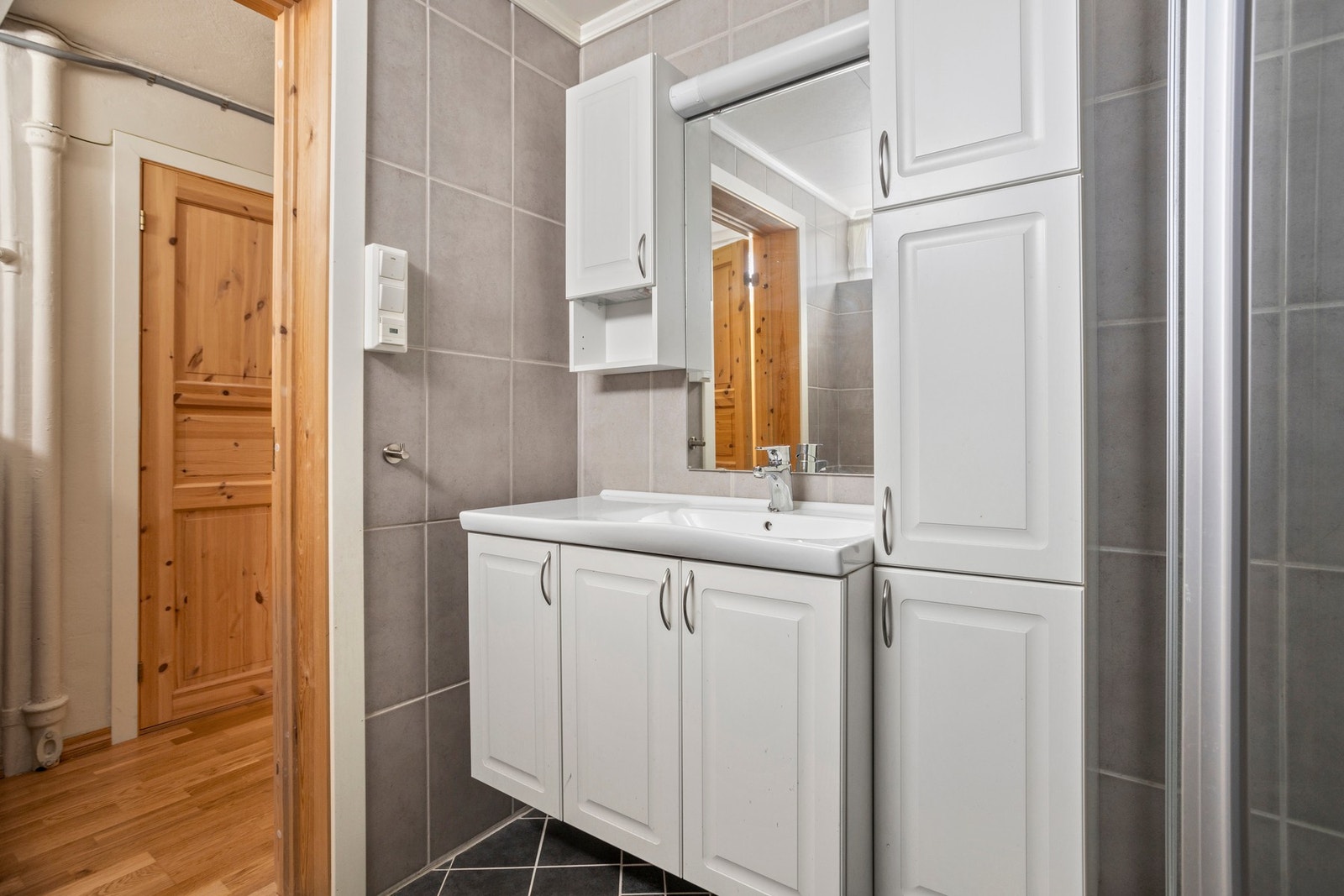 Badet er utstyrt med servantskap, toalett og dusjkabinett Galleribilde