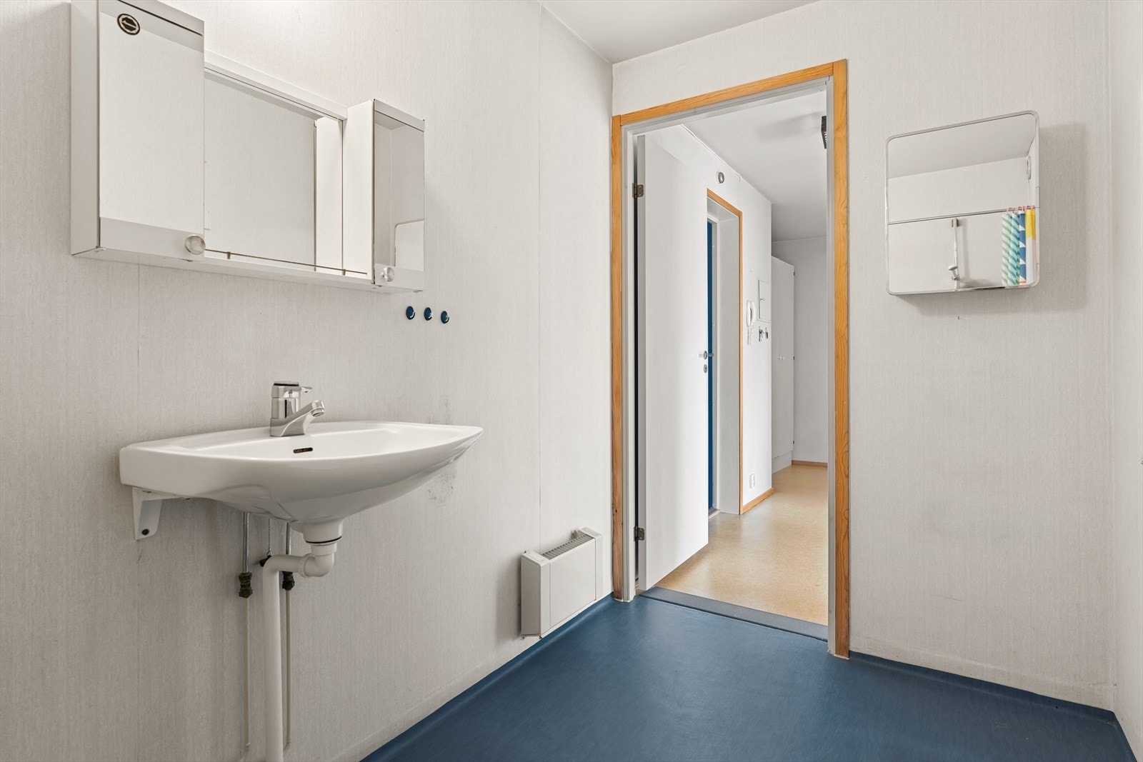 Innredning og garnityr med servant og speilskap, dusjplass med forheng, WC, samt opplegg for vaskesøyle. Galleribilde