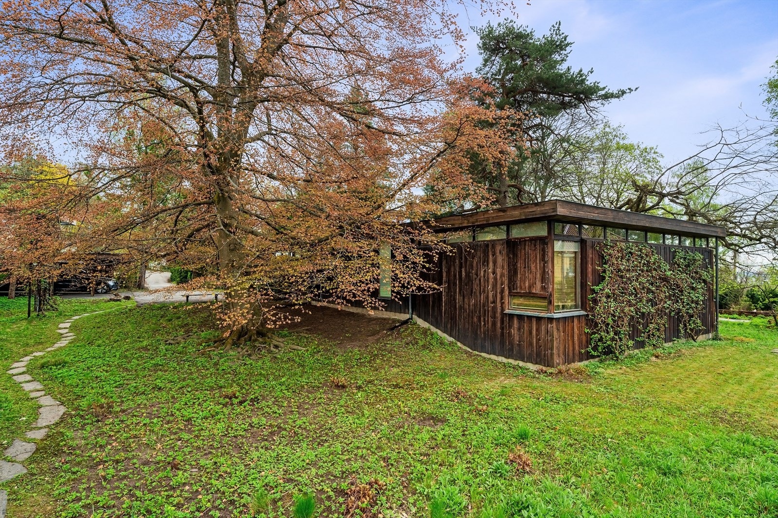 Dette huset er en komposisjon av rektangulære, svartbeisede volumer. Hageanlegget har sine forbilder fra japansk hagekunst. Galleribilde