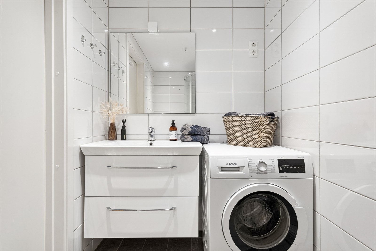 Badet er innredet med pen vegghengt heldekkende servant og skuffeseksjon. Opplegg for vaskemaskin. Galleribilde