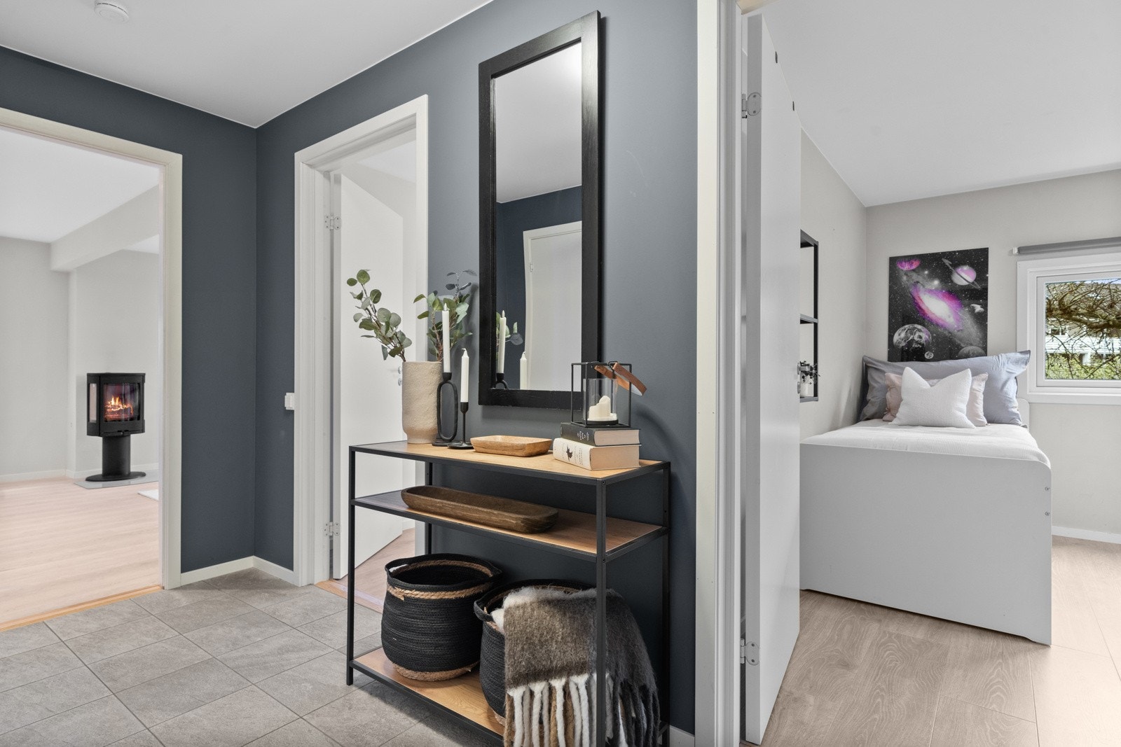Entreen har grå fliser på gulv med gulvvarme, vegger malt i en behagelig blåtone og listefritt tak. Galleribilde