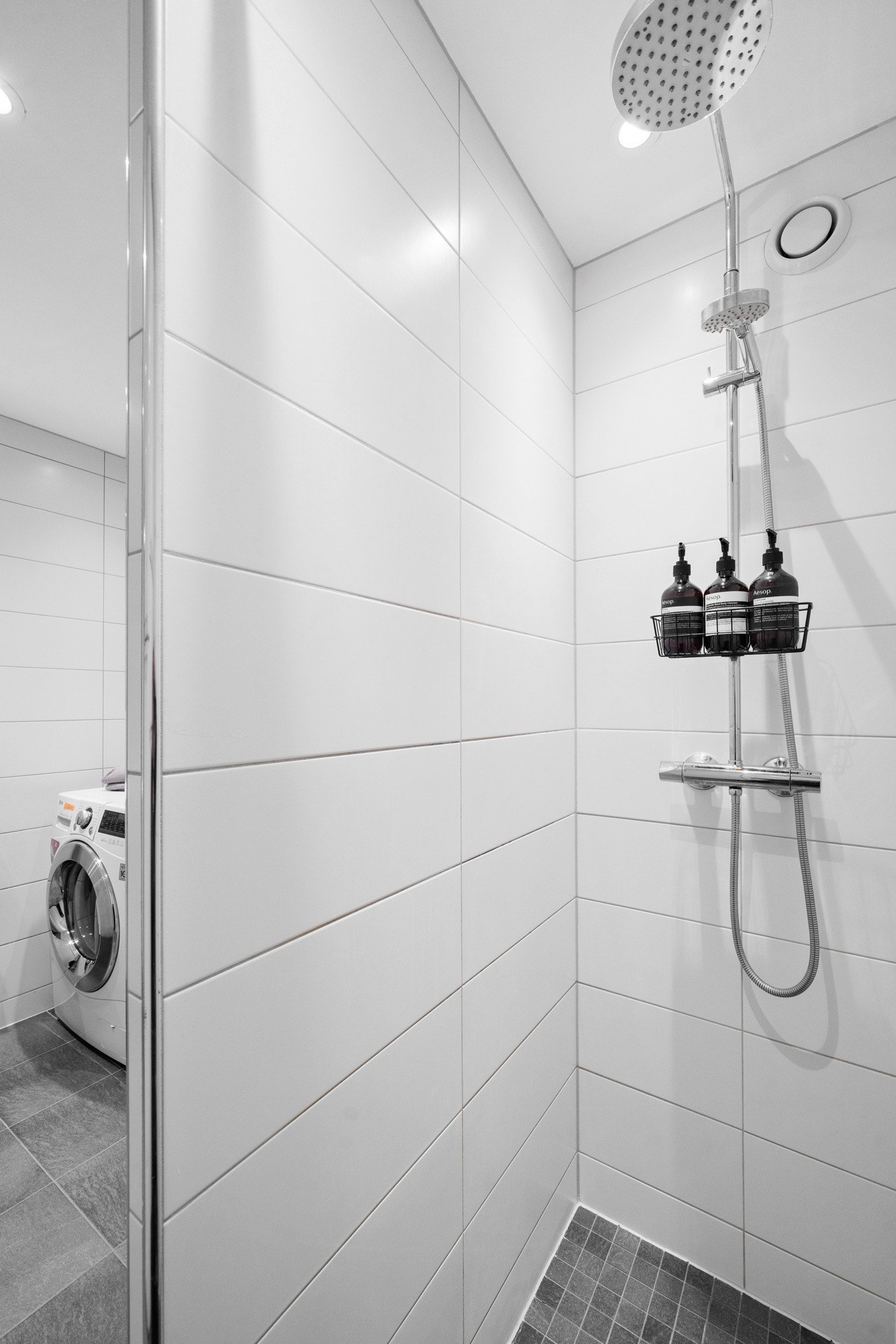 Badet har et pent dusjhjørne med flislagt skillevegg, regnfallsdusj og hånddusj. Det er lagt mosaikkfliser på gulv i dusjsonen. Galleribilde