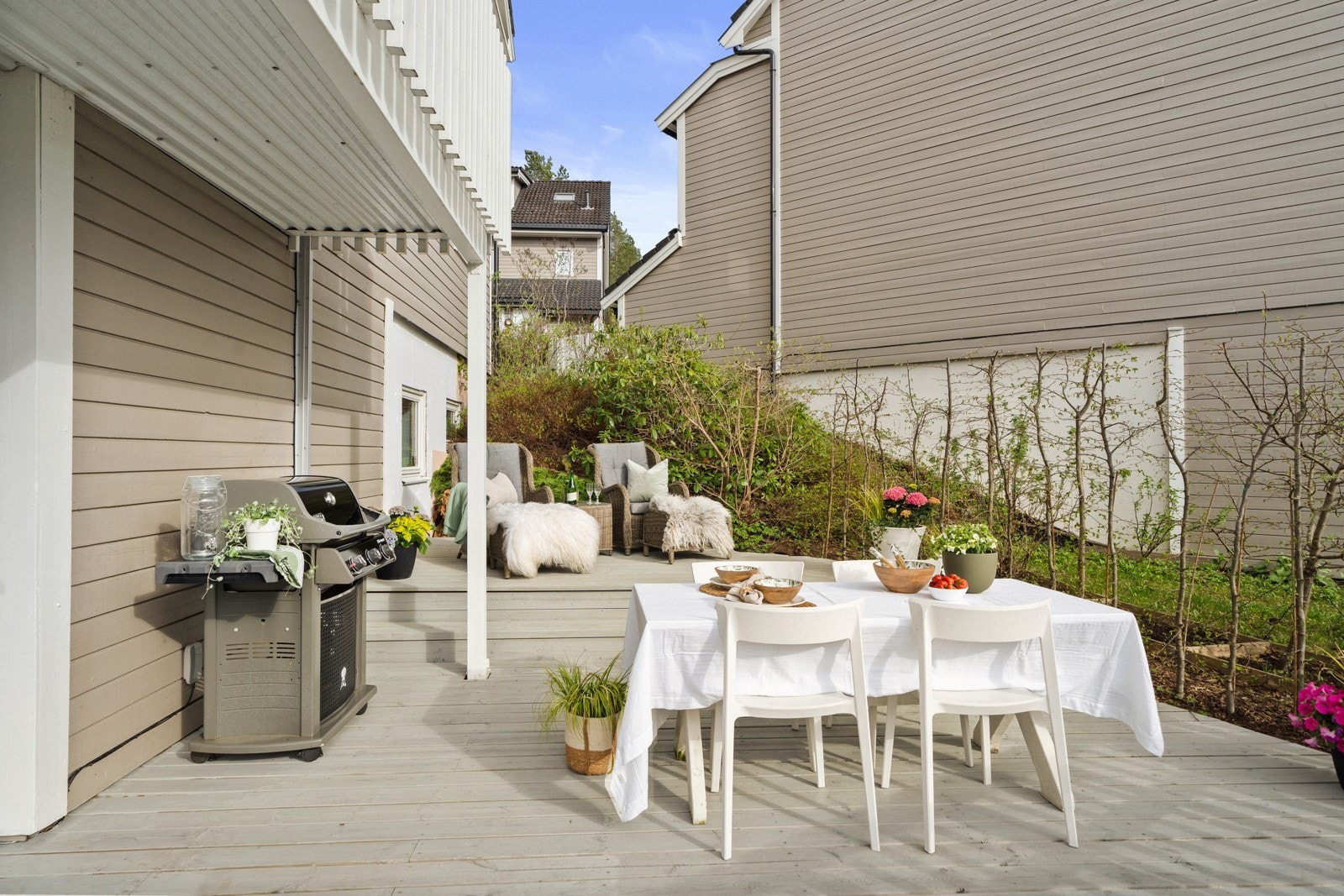 Uteplassen har dekke av terrassebord og hvitmalt rekkverk rundt om som ble byttet i 2018. Videre er det en rekke prydvekster langs grensen mot nabo. Galleribilde