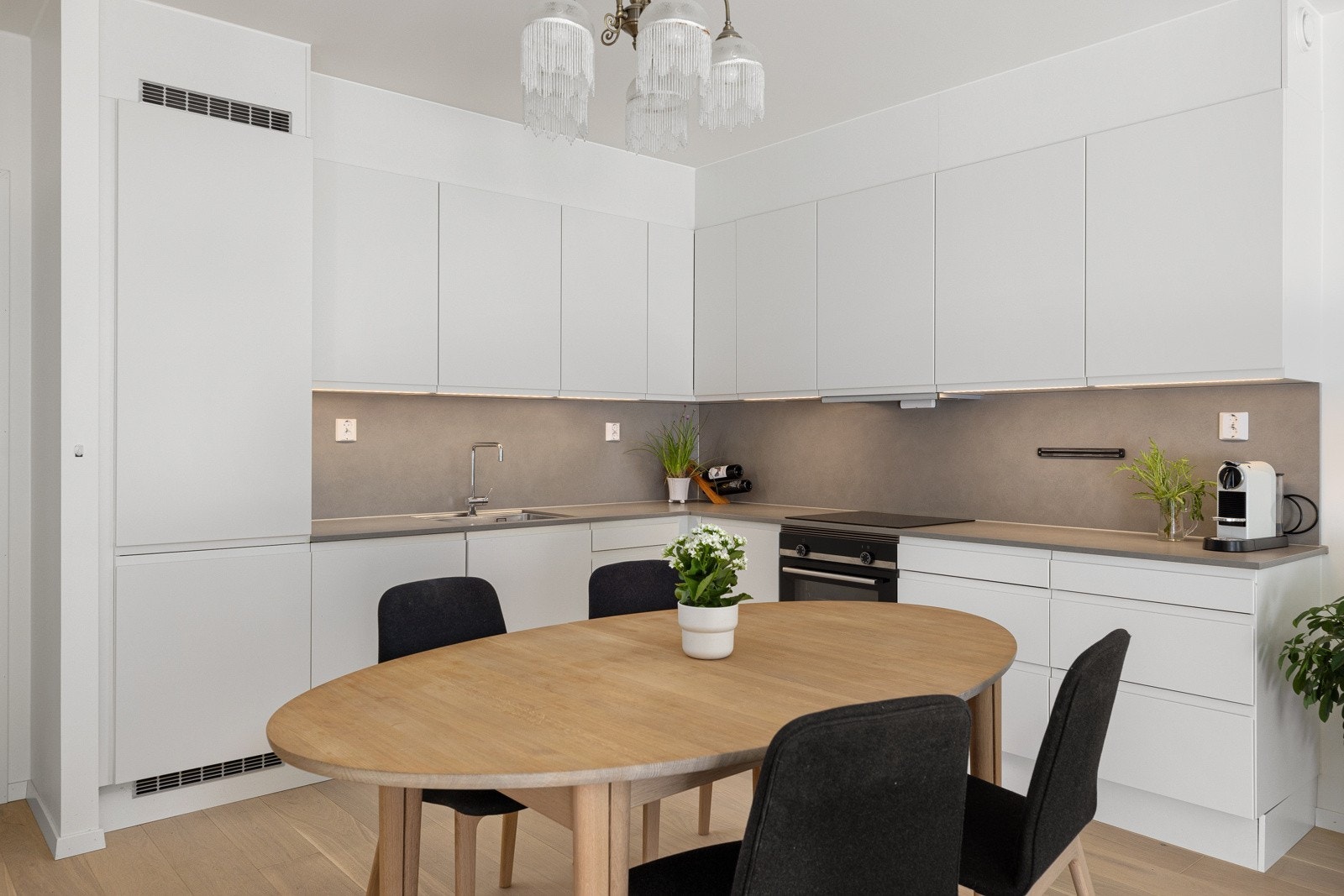 Innredningen har glatte fronter, laminat benkeplate og plater mellom over- og underskap. Galleribilde