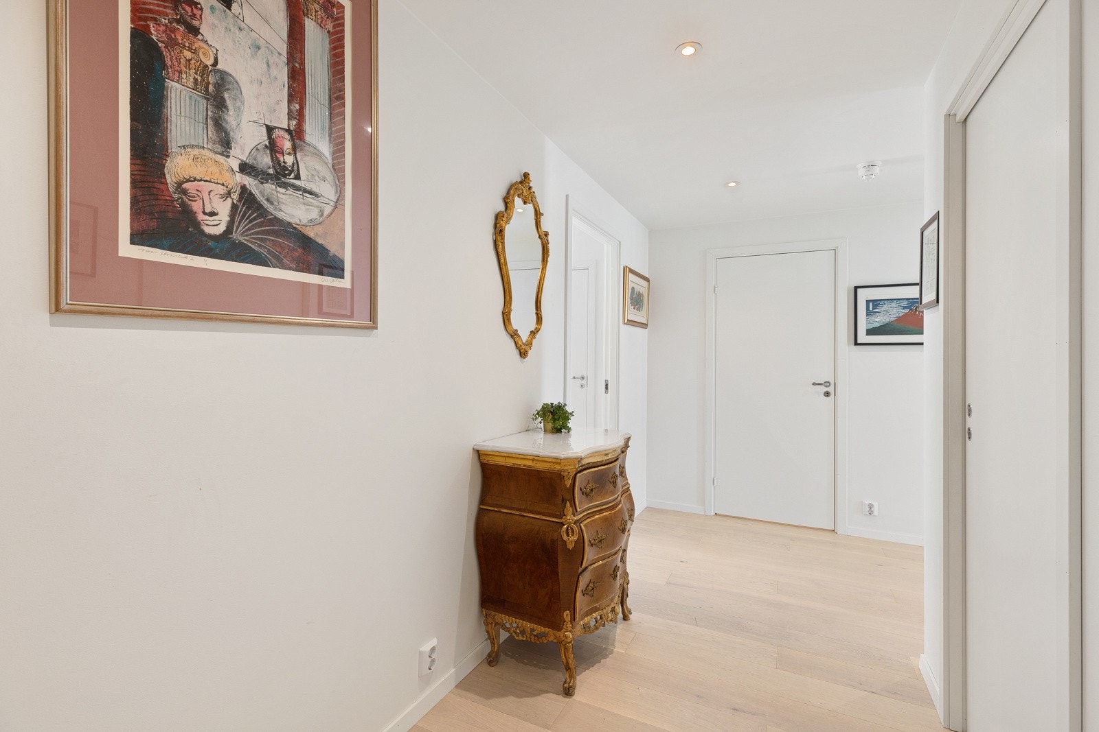Entré har en-stavs eikeparkett på gulv og lysmalte overflater, noe som også er gjennomgående i resten av leiligheten. I entréen er det god plass til møblement for oppbevaring av sko og yttertøy. Galleribilde