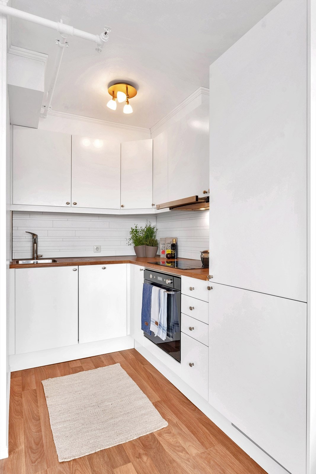 Flott kjøkken med slette fronter og integrerte hvitevarer. Galleribilde