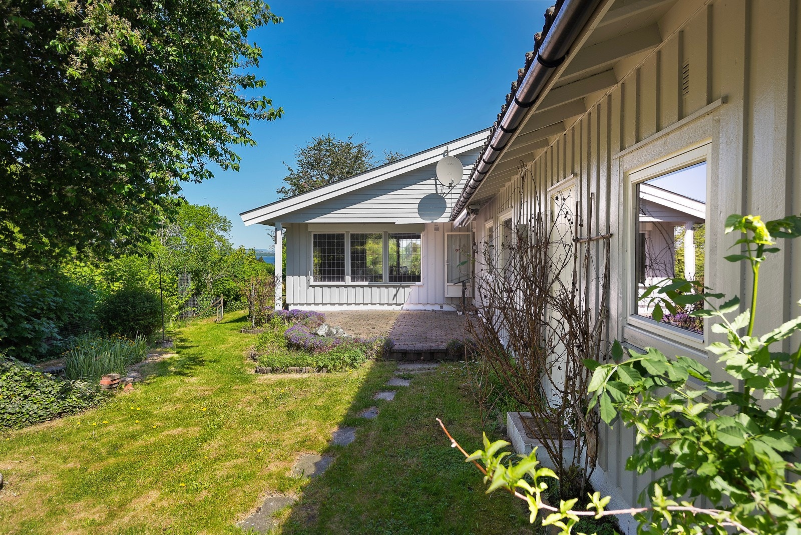 Idylisk hage med egen hagedam til venstre i bilde Galleribilde